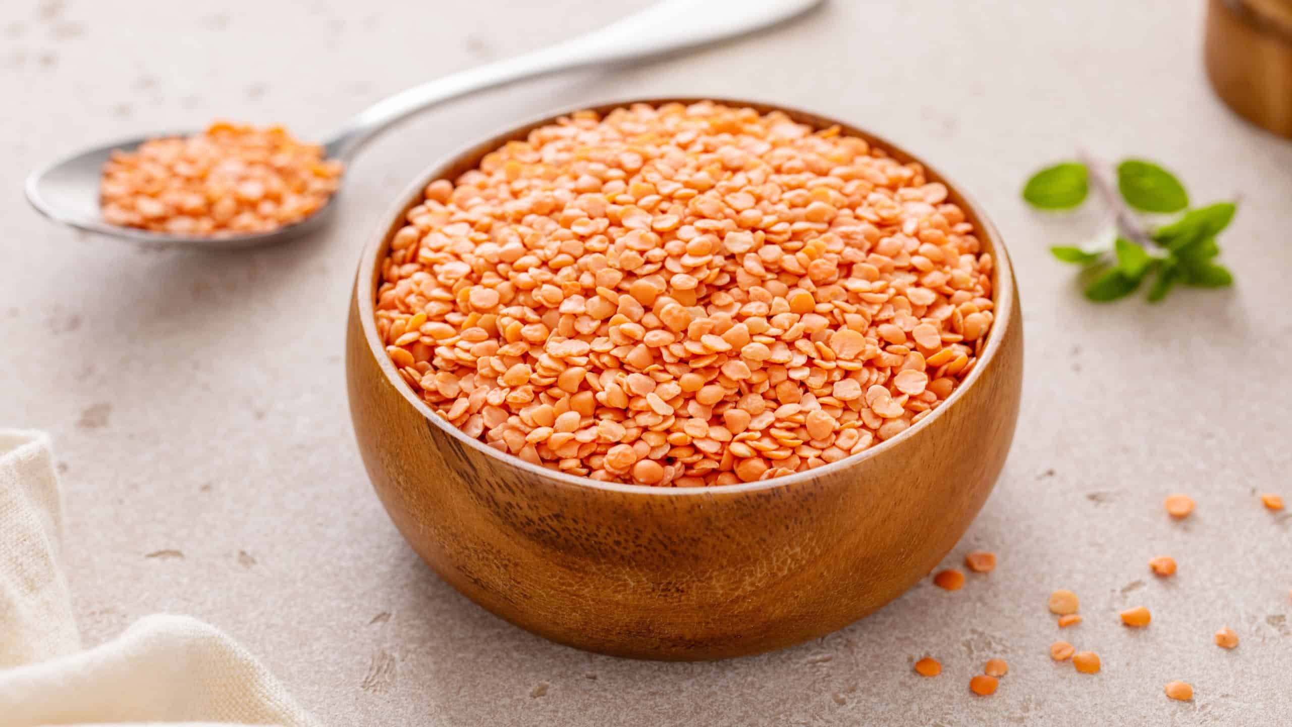 Red lentils raw in a bowl ready to be cooked, healthy vegan protein source