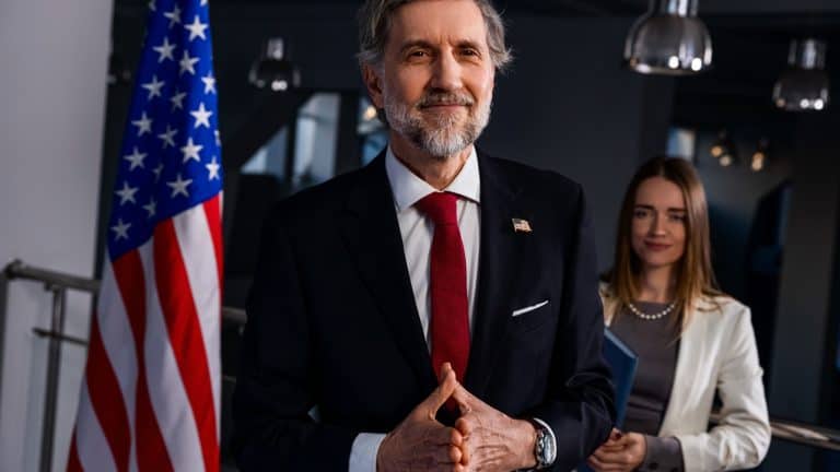 New President of the United States comes to journalists and media, poses for cameras after election winning. Happy American politician smiles and gestures during live broadcast on TV. Press conference