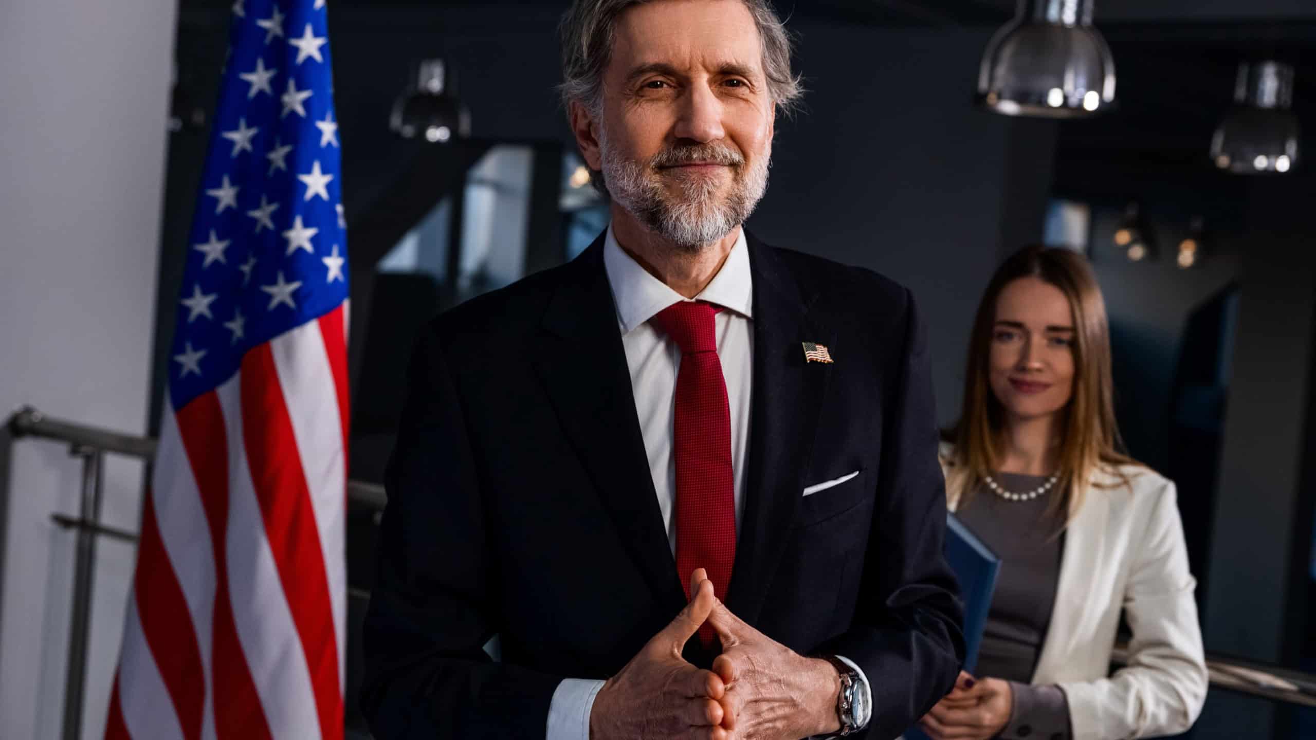 New President of the United States comes to journalists and media, poses for cameras after election winning. Happy American politician smiles and gestures during live broadcast on TV. Press conference