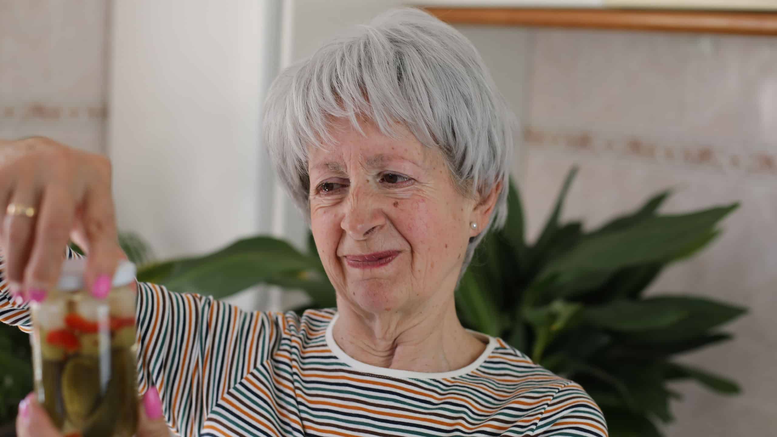 Senior woman trying to open a jar