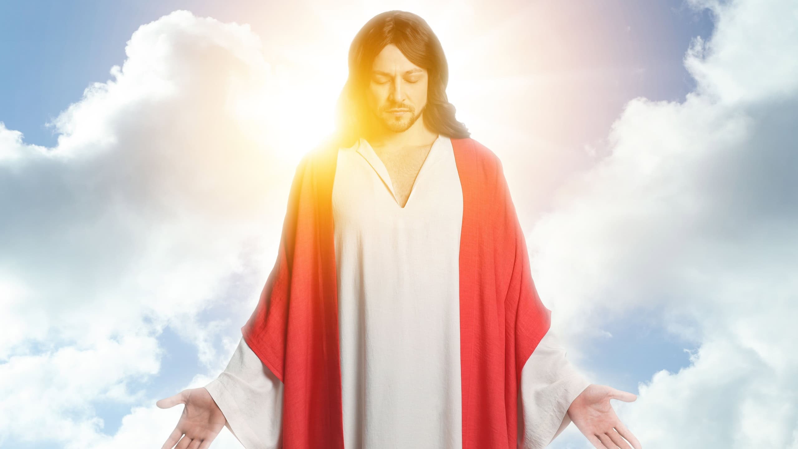 Jesus Christ in sunlight among clouds in sky