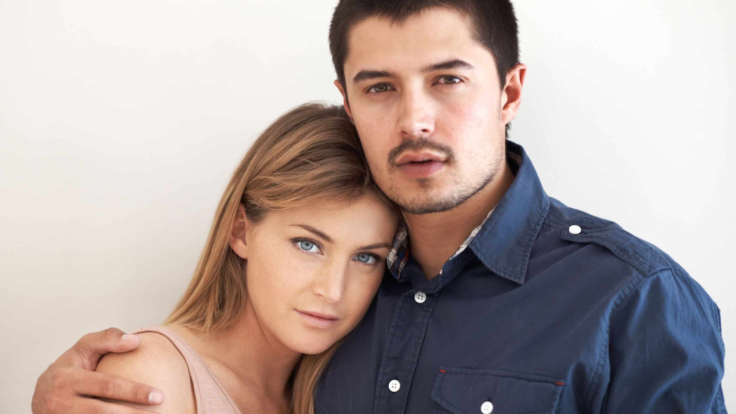 Serious, hugging and portrait of couple in studio with love, marriage and romantic connection.