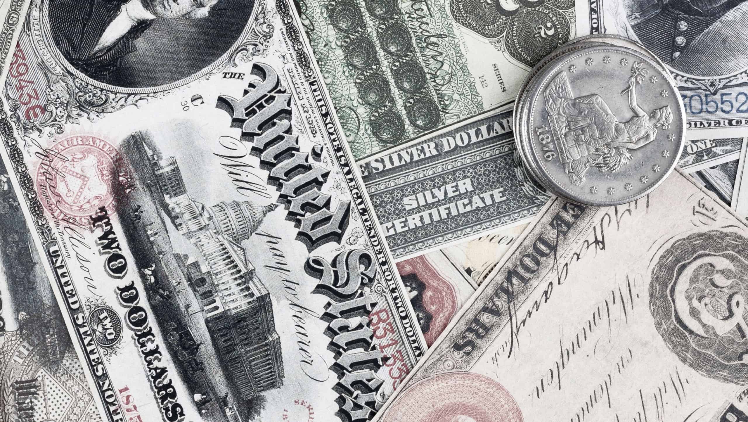 Old west US banknotes and silver certificates with silver dollar coins background