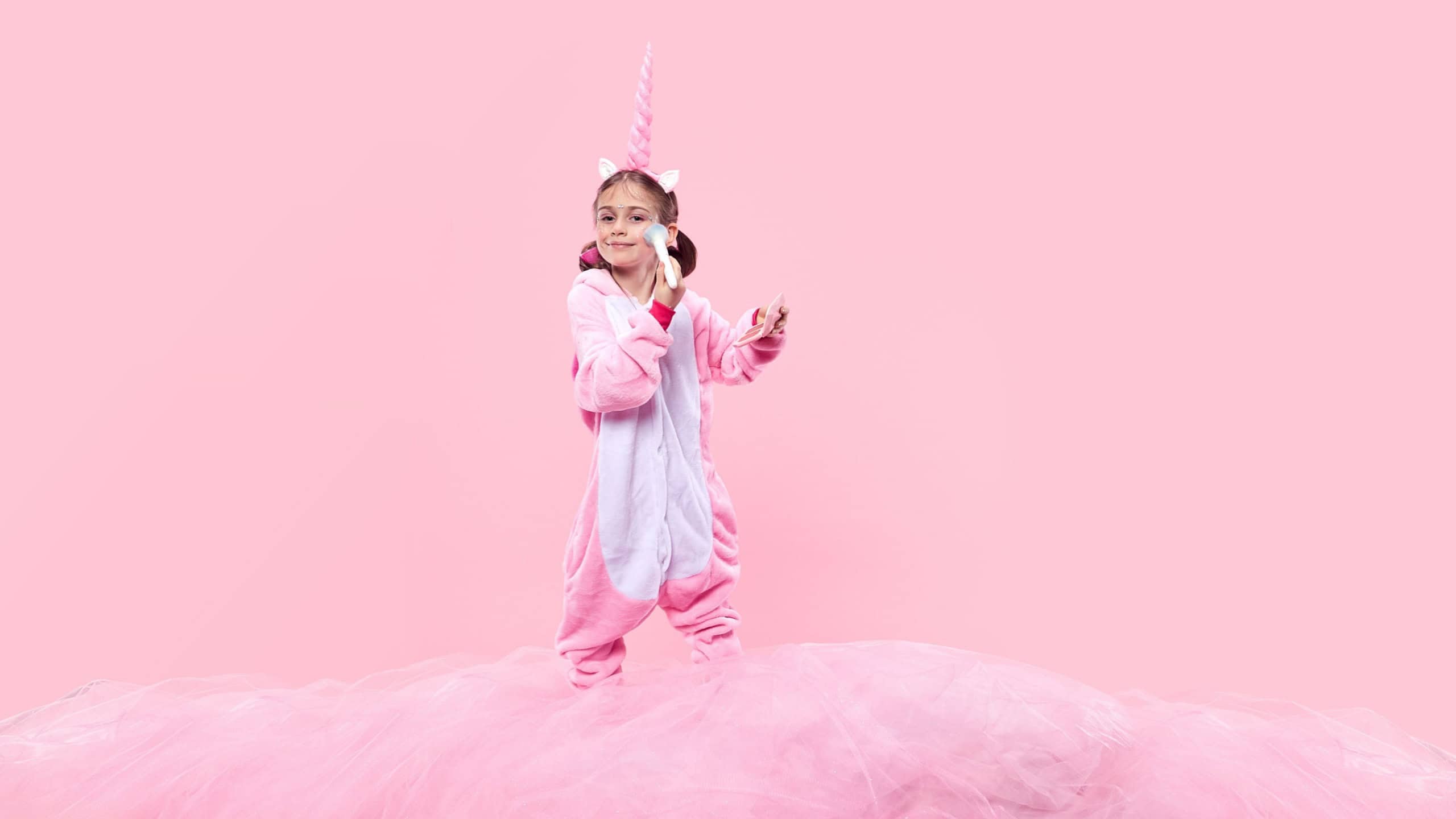 Smiling, happy girl in pink unicorn costume