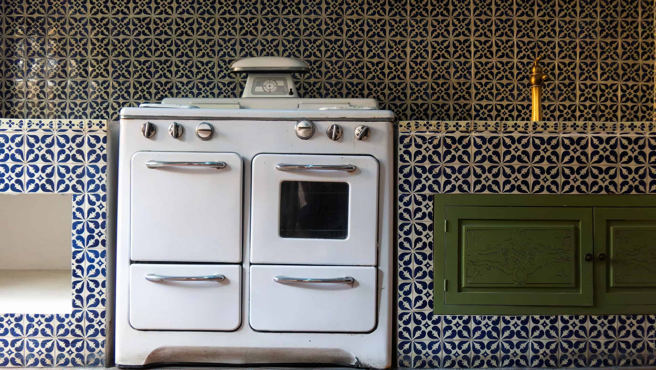 Vintage kitchen stove in a beautifully tiled interior space with colorful patterns