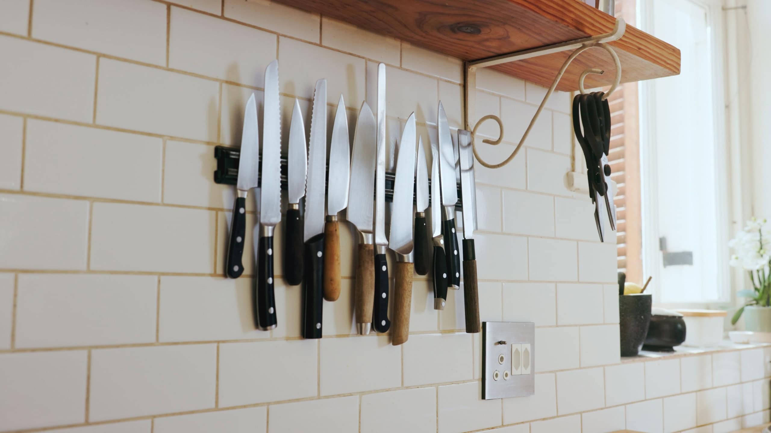 Kitchen, wall and magnetic knife holder with cooking equipment for catering in small business. Steel blade, culinary tools and storage design of utensils, metal cutlery and arrangement in restaurant