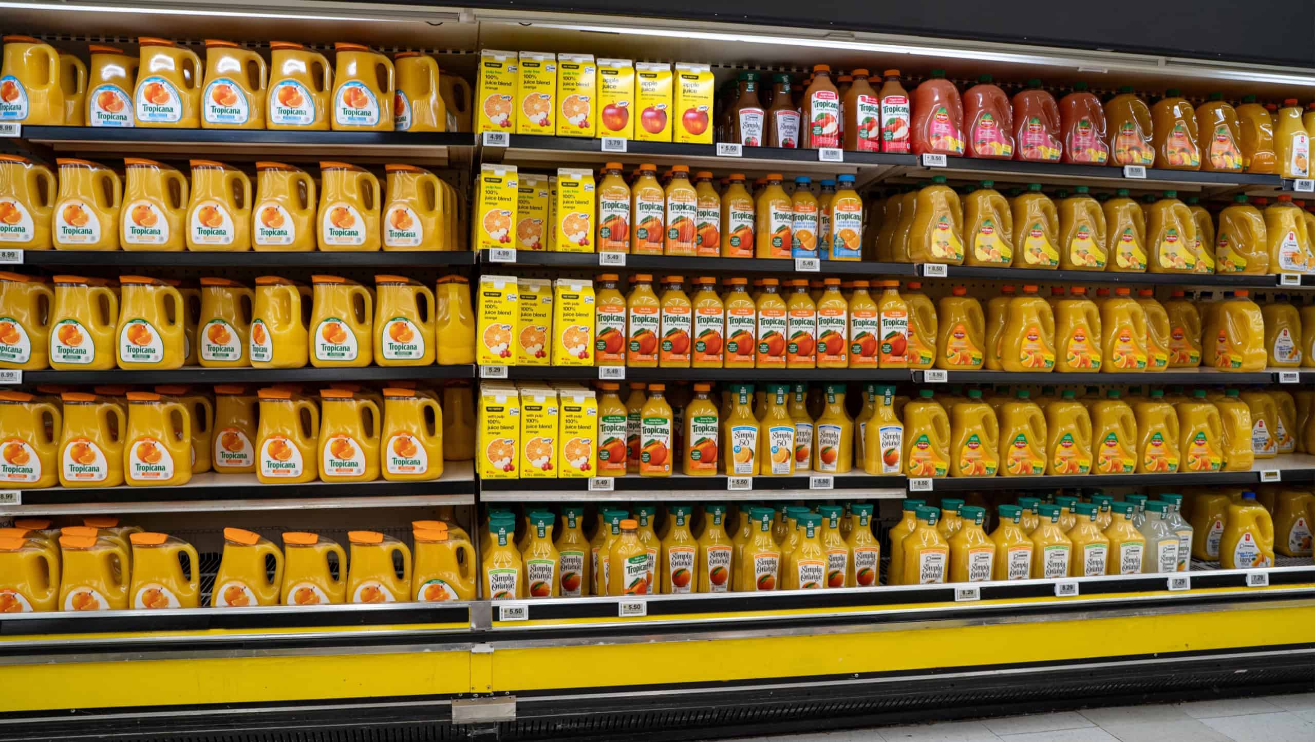 Assorted orange juice bottles and cartons on supermarket shelf. Toronto, Canada - October 3, 2025.