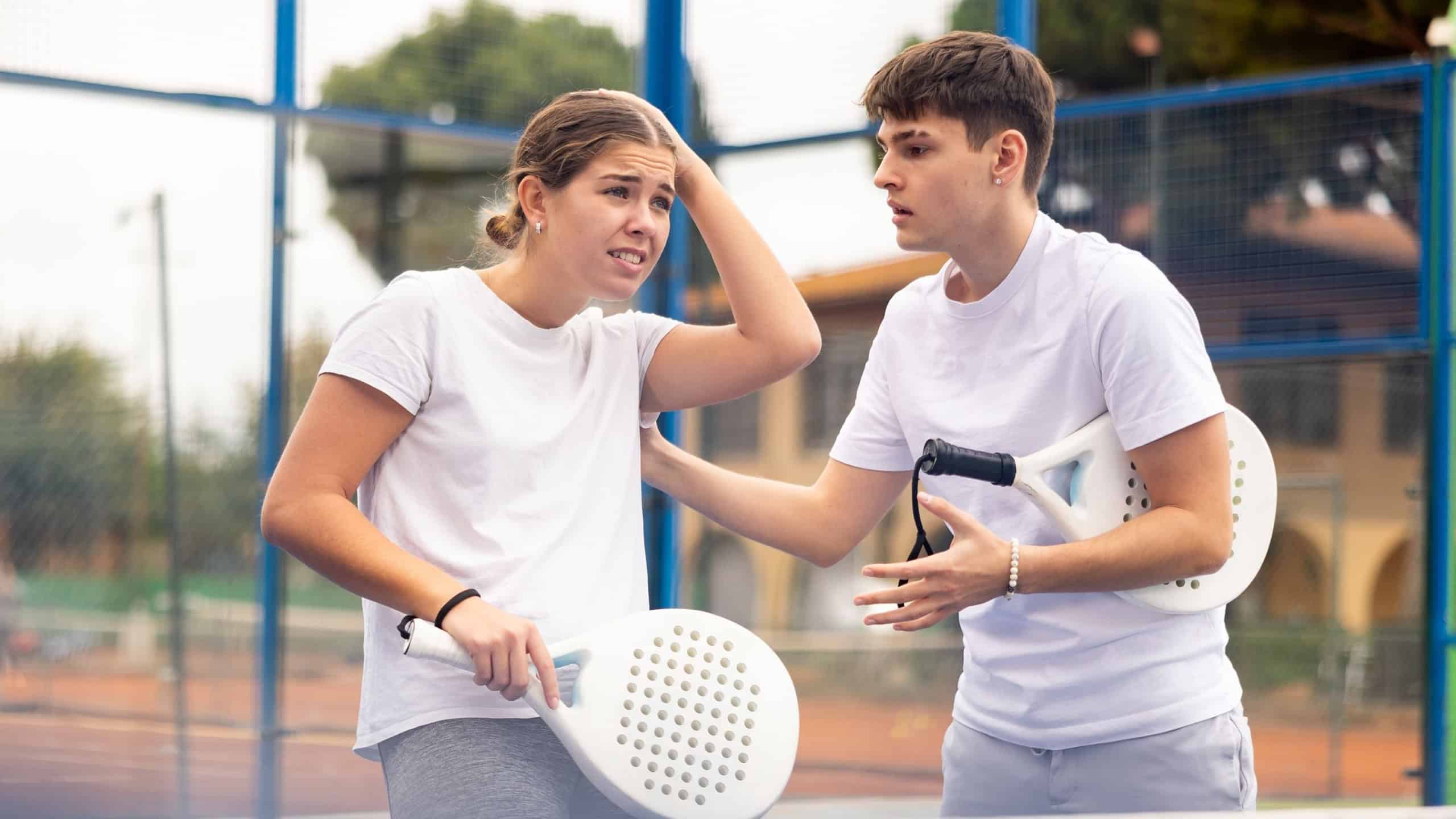 Young padel player calm down his partner after a lost game