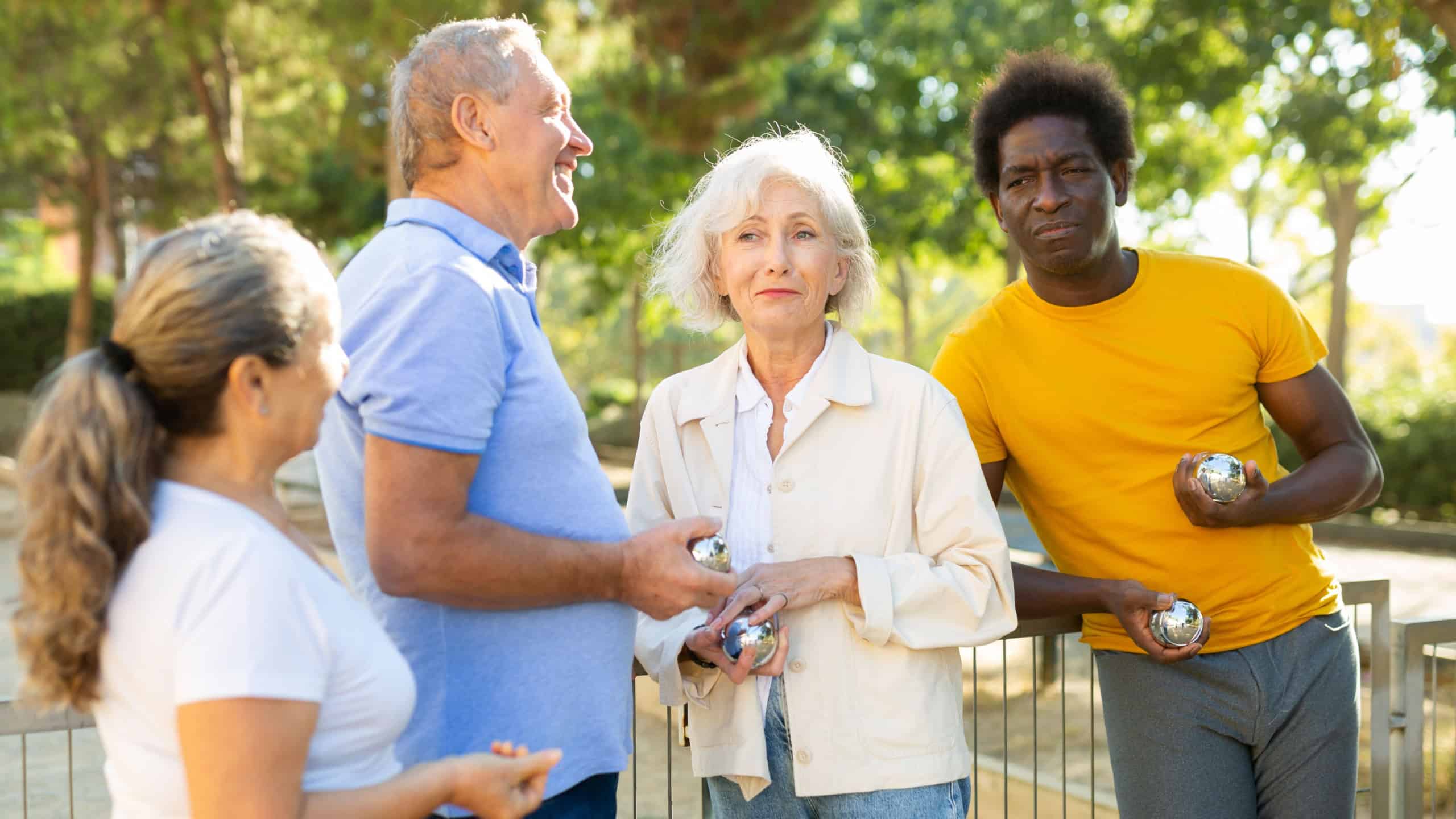 Two adult couples share their impressions after playing petanque outdoors