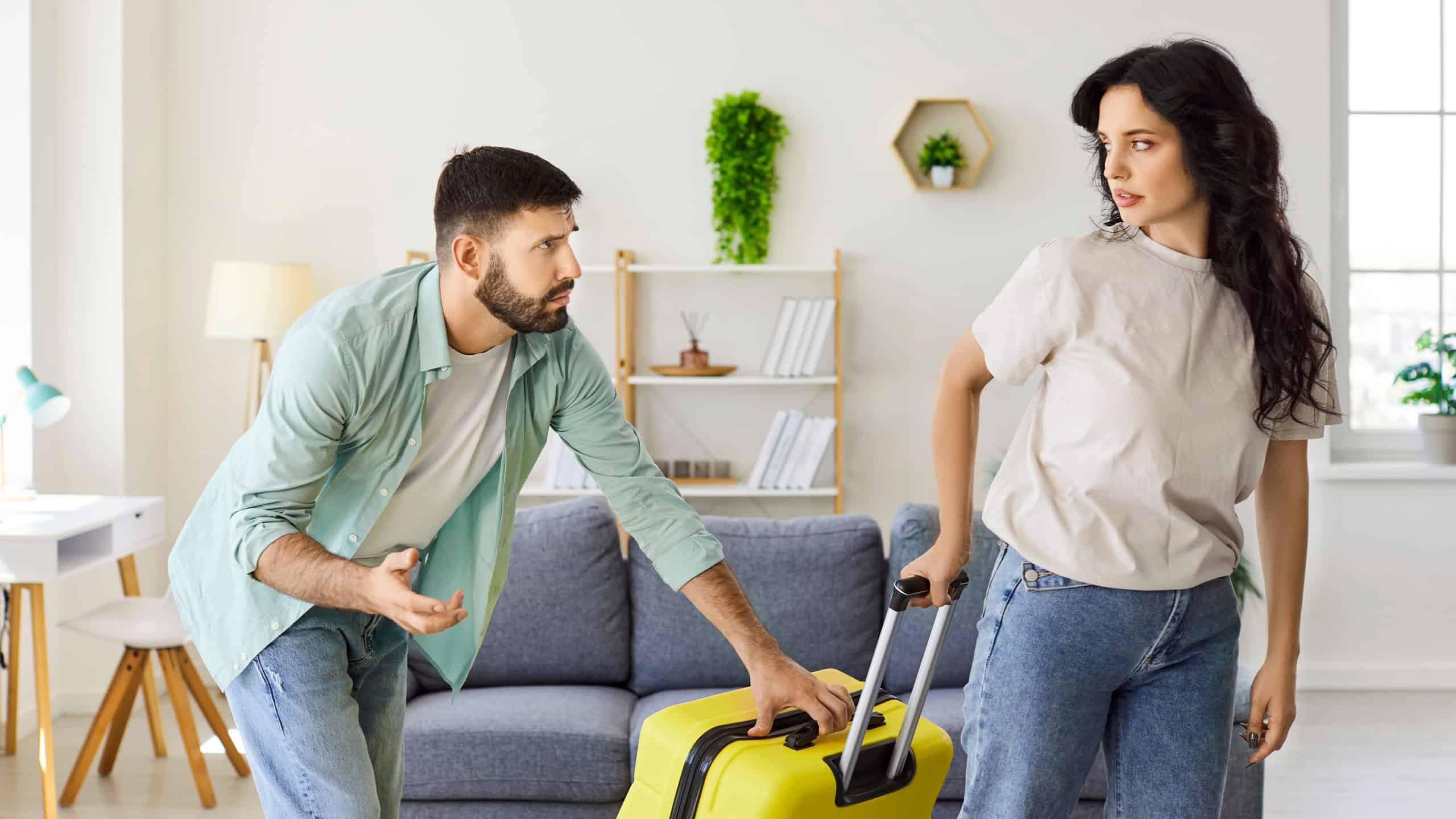 Couple argument at home over suitcase and leaving.