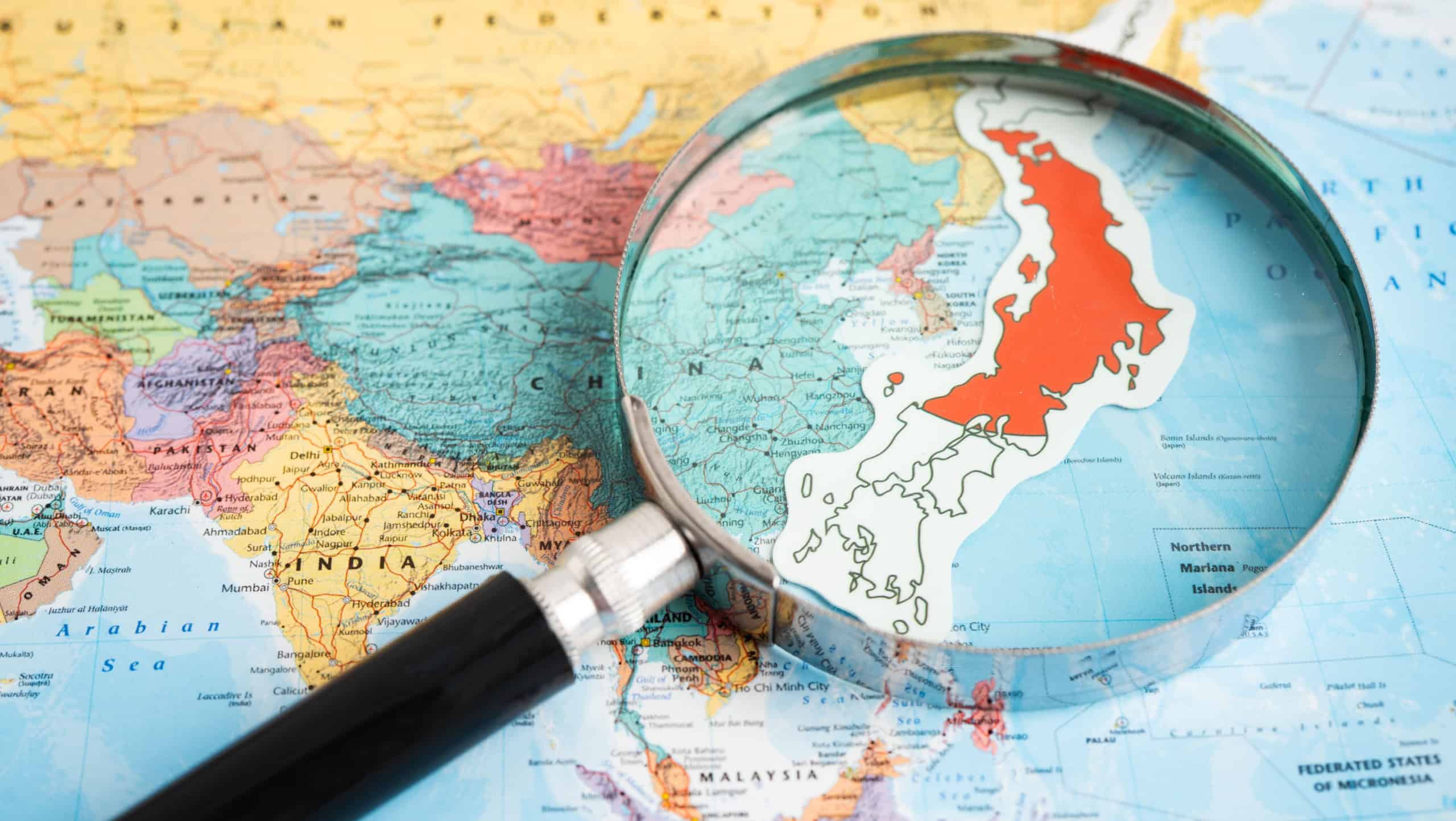 Bangkok, Thailand January 20, 2022 Japan, Magnifying glass close up with colorful world map, travel, geography, tourism and exploration.