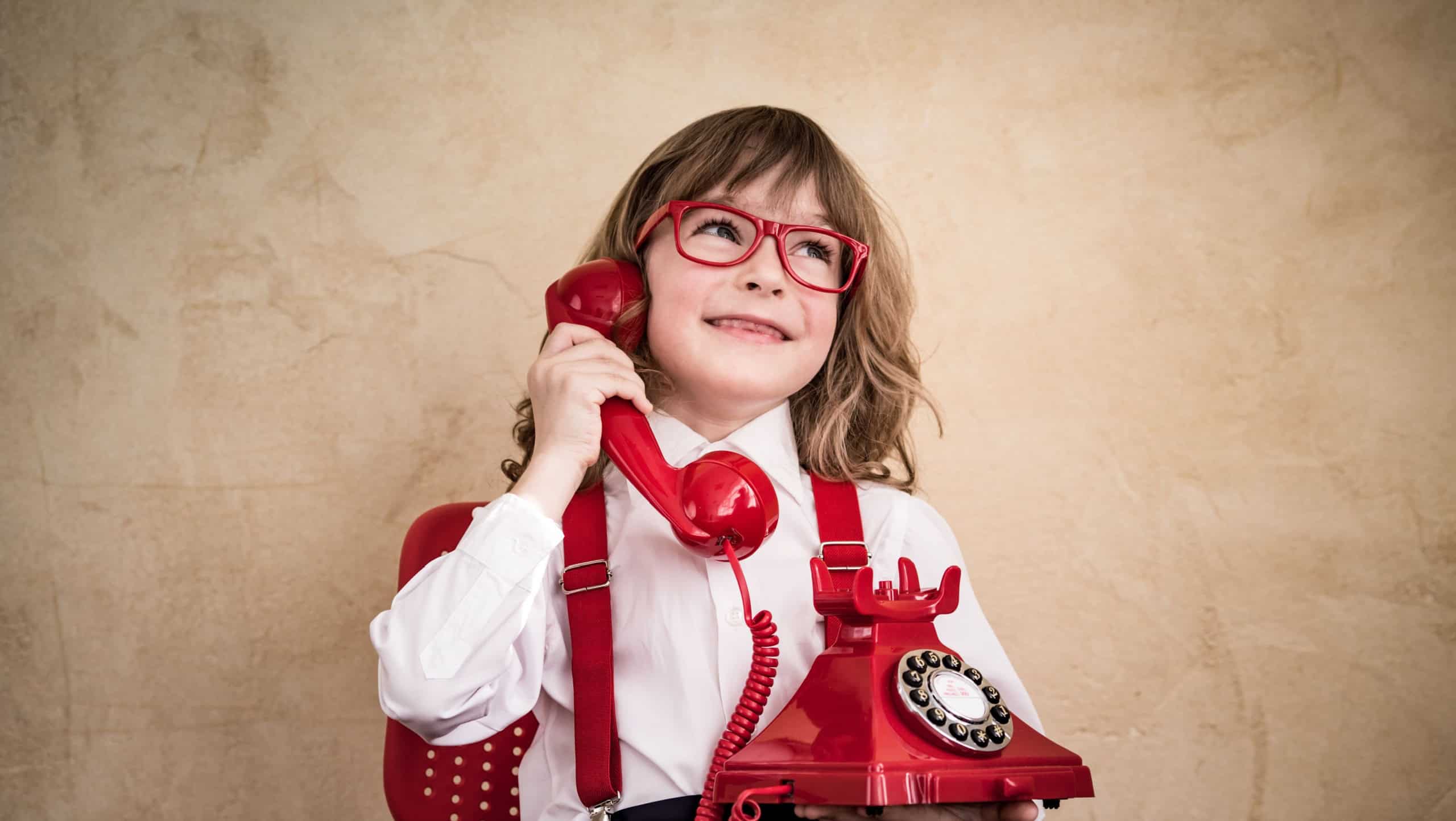 Happy child businessman with retro phone. Communication in business concept