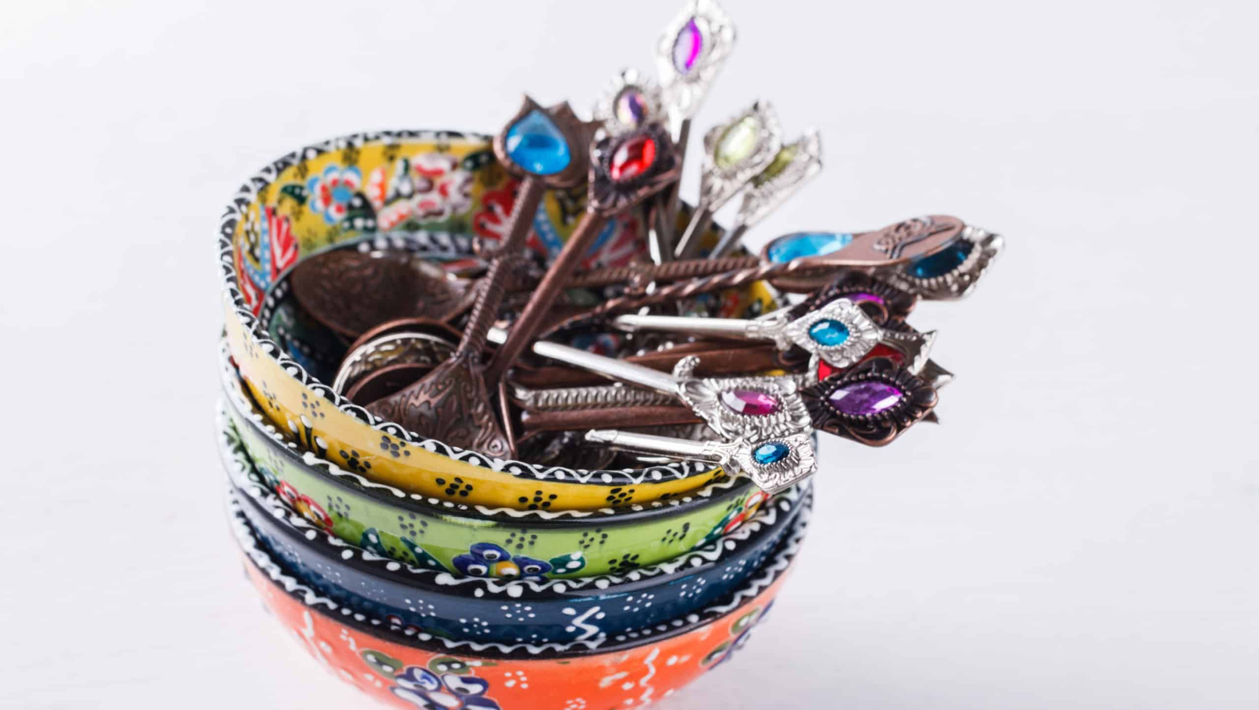 Traditional Turkish hand made ceramics,spoons with colored stones on white background.selective focus.