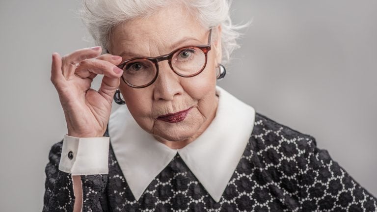Stylish adult female looking from over her eyeglasses