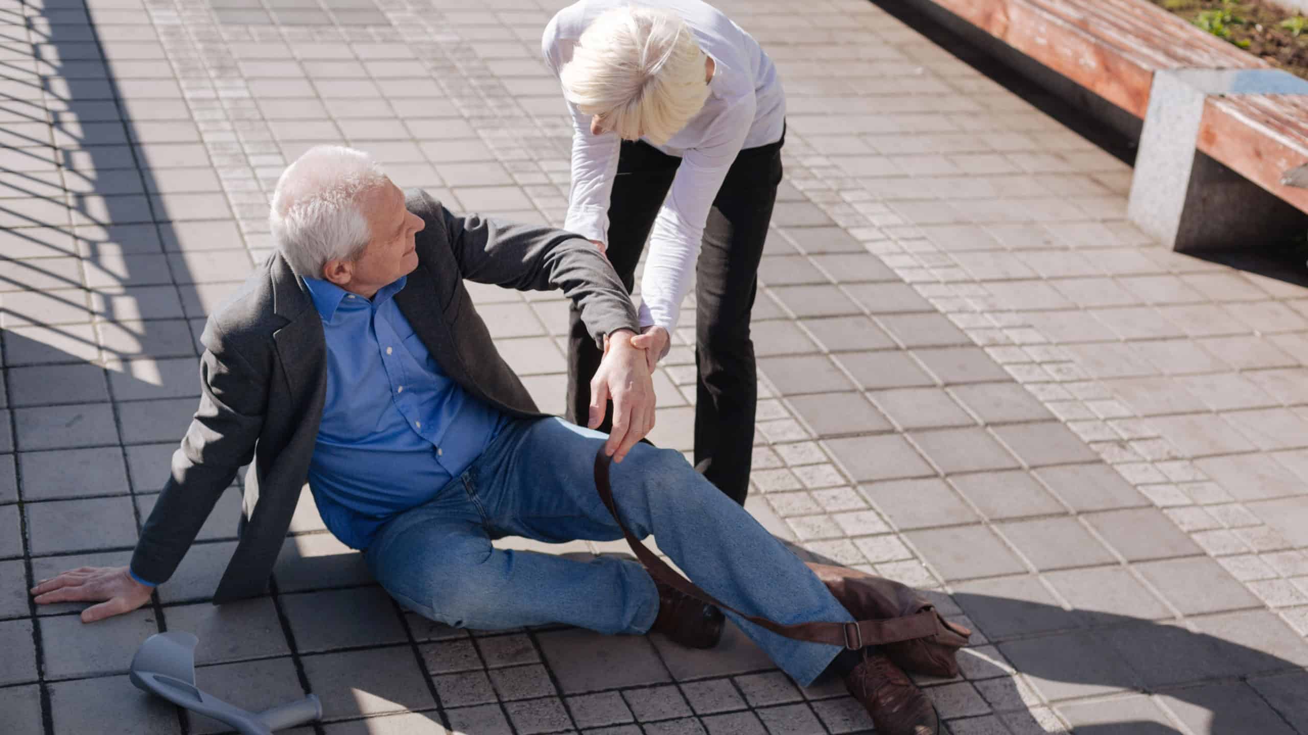 Tired aging man falling down on the road
