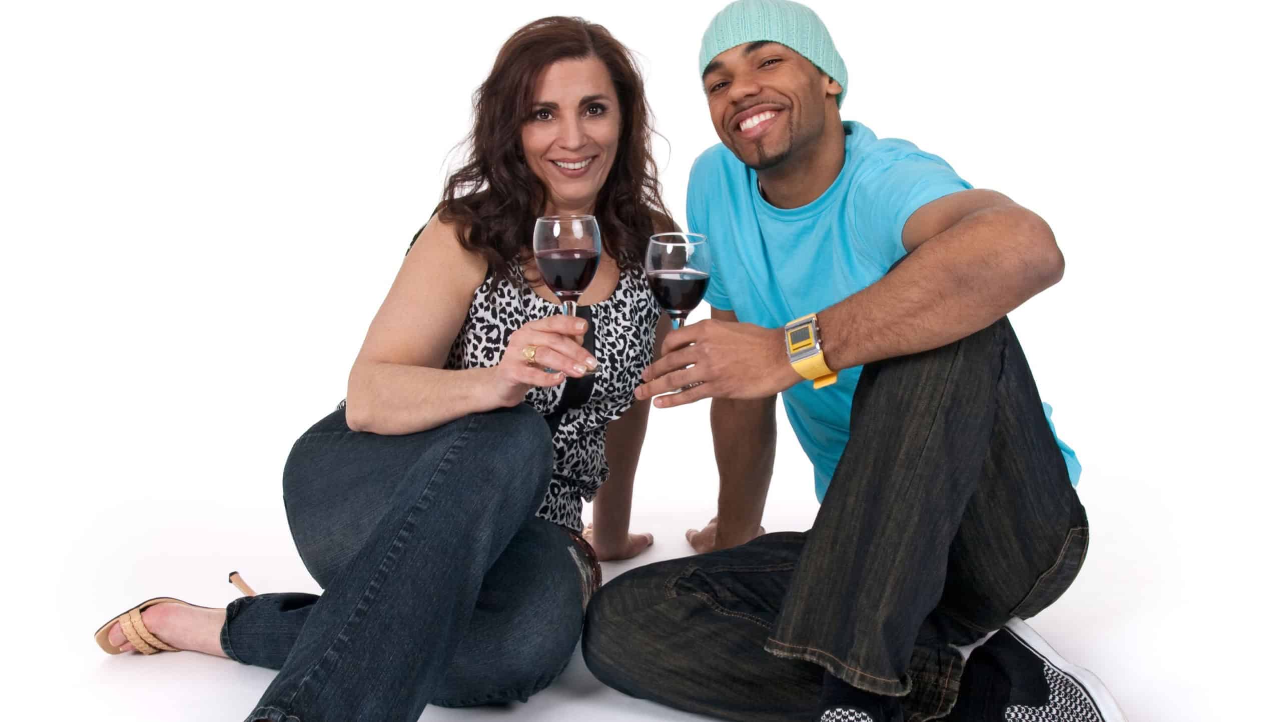Mature woman with a young man drinking wine, sitting close to each other.