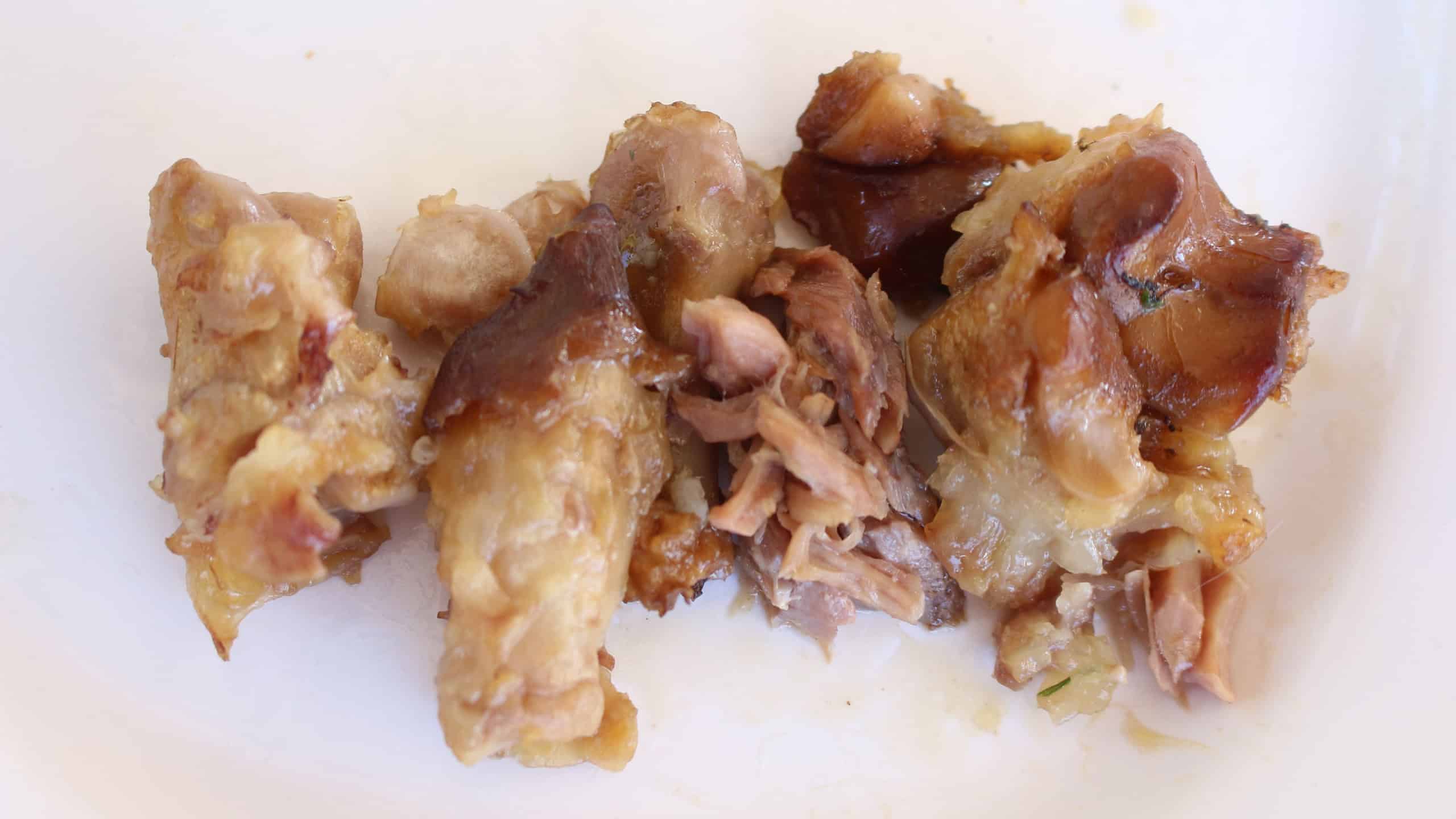 Fragments of bone in white plate After eating pork leg soup.