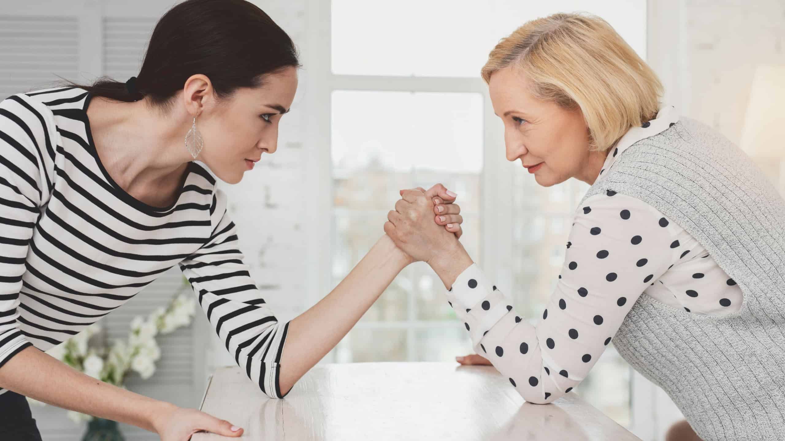 Family battle. Nice young woman looking at her mother in law while having a competition with her