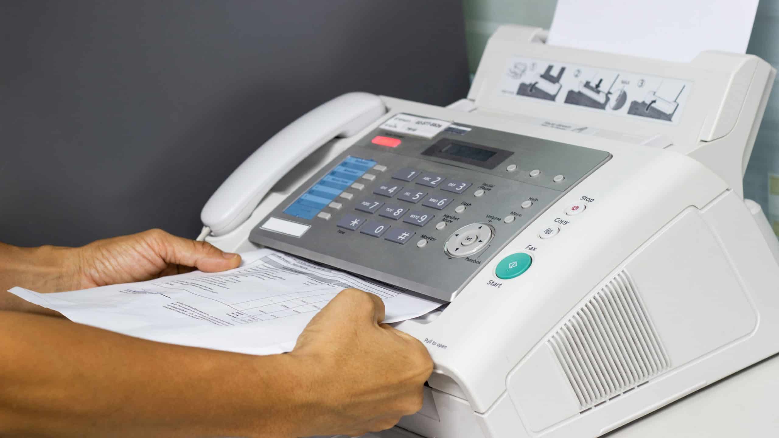 Man using a fax machine in the office Business concept
