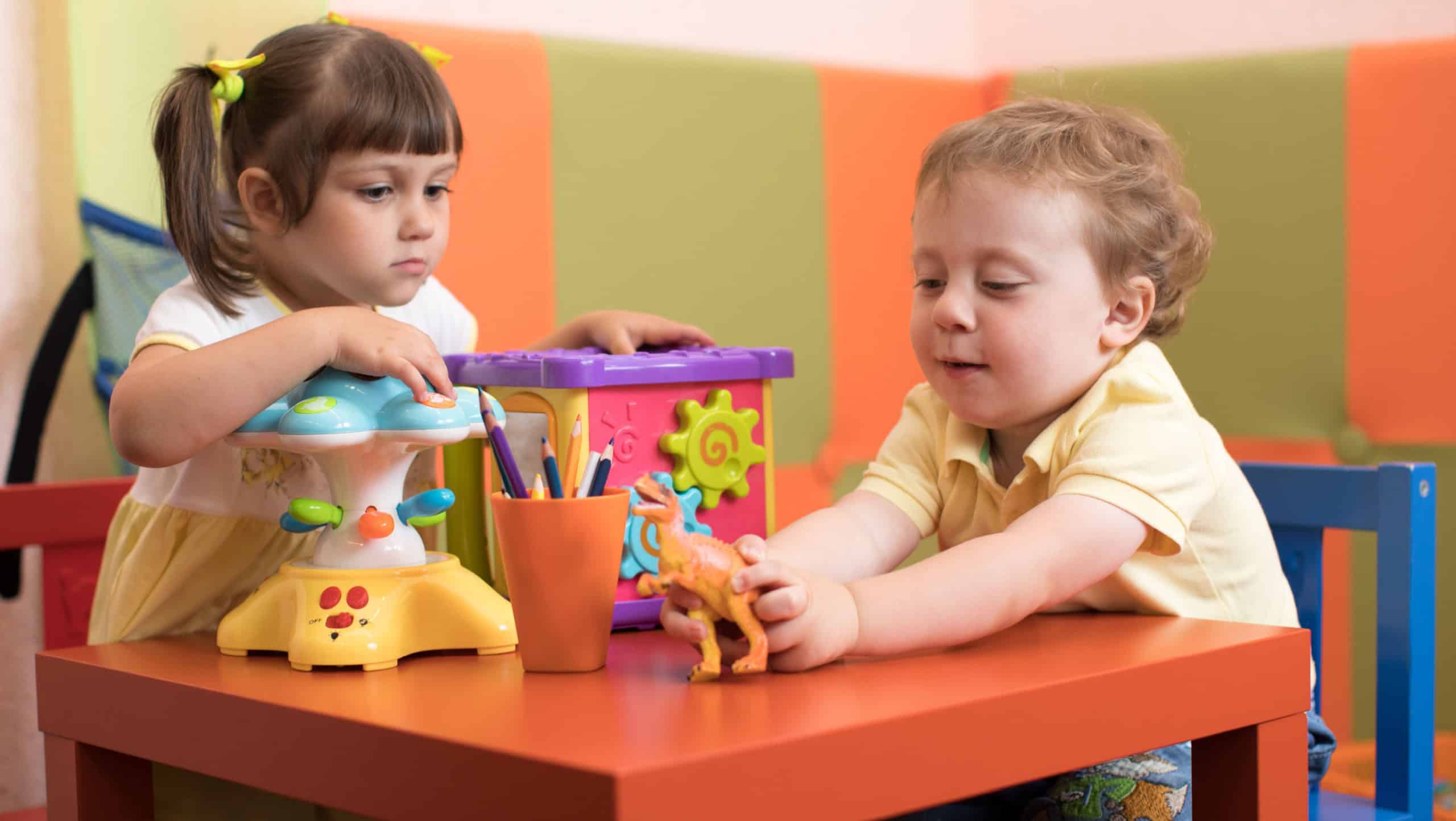 Children girl and boy play in kids daycare centre