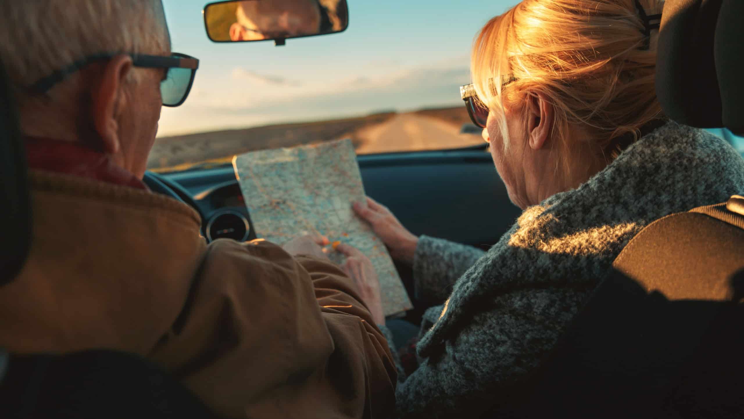 Elderly loving couple traveling in car on vacation.