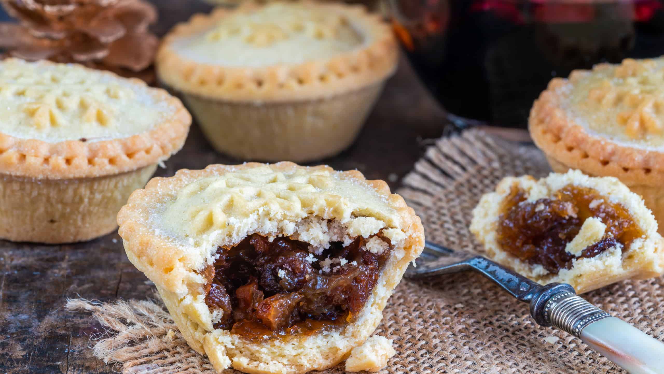 Traditional Christmas mince pies and mulled wine on wooden table