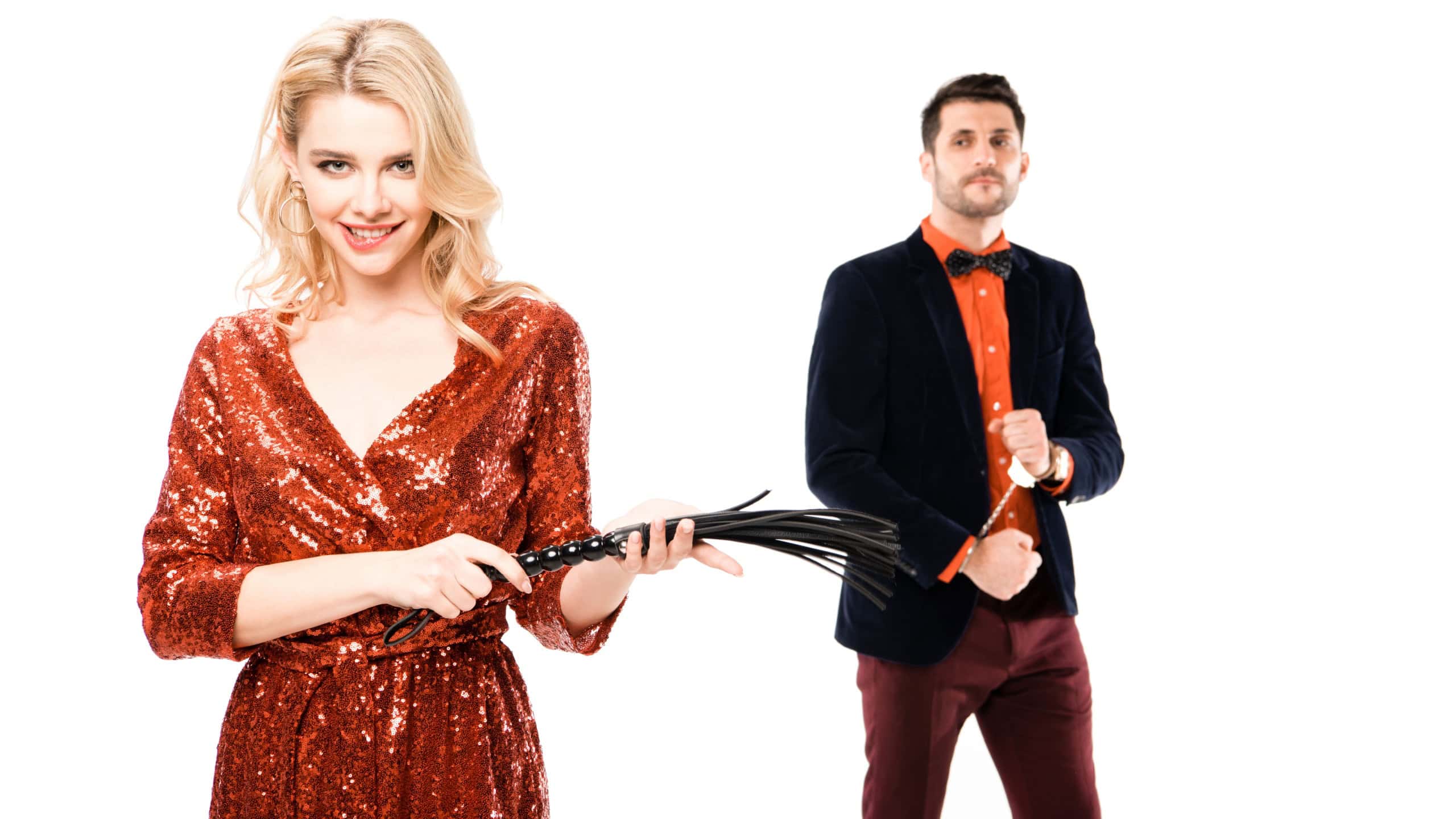 Woman holding a whip and man in a suit with a serious expression.