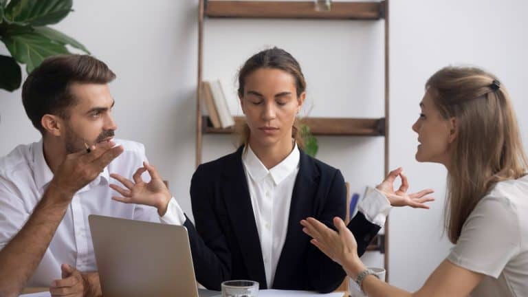 Managing stress at work concept, calm office worker meditating at workplace ignoring arguing colleagues at stressful meeting, business conflicts, peace of mind, patience control and mental health