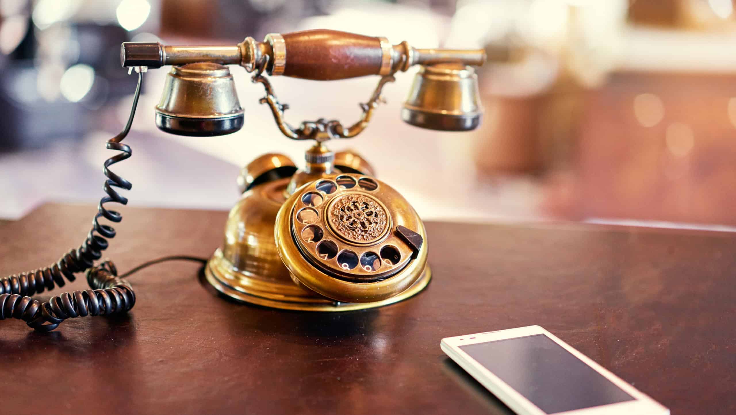 Connection concept. Analog and digital. Old fashioned telephone and modern smartphone on table.