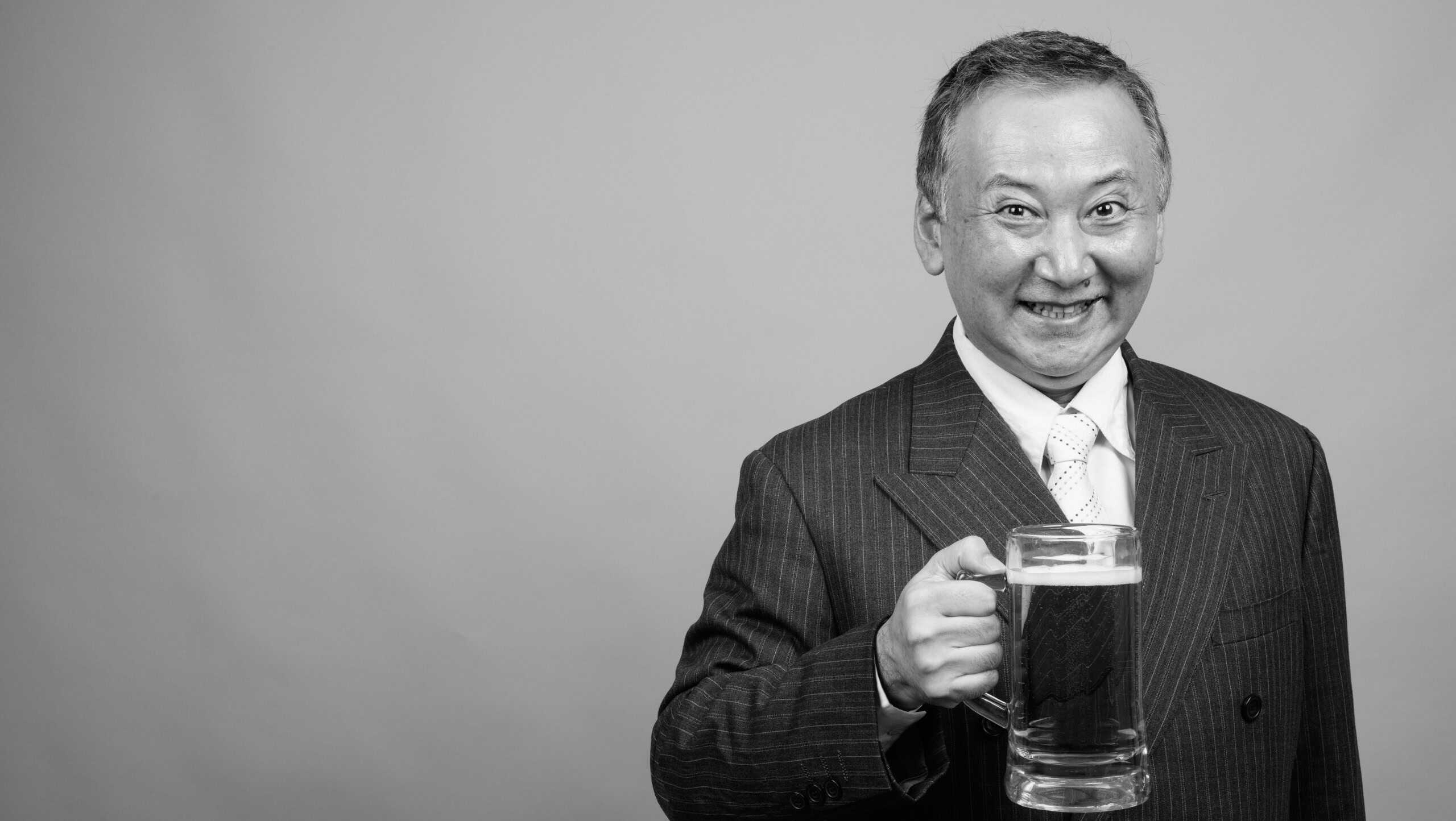 Portrait of mature Asian businessman against gray background