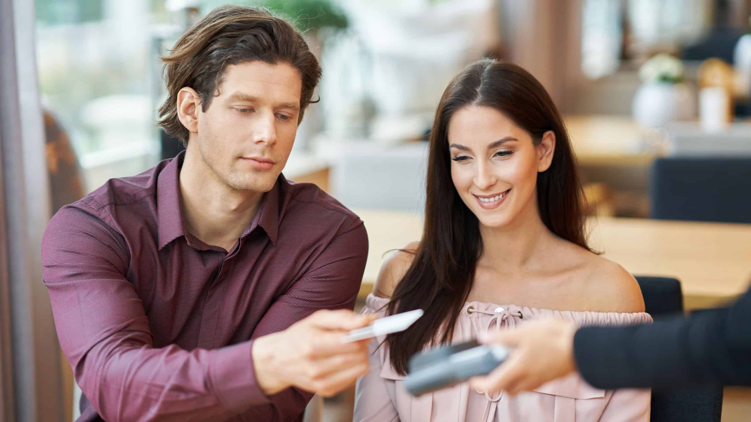 Young Couple paying by credit card in Cafe