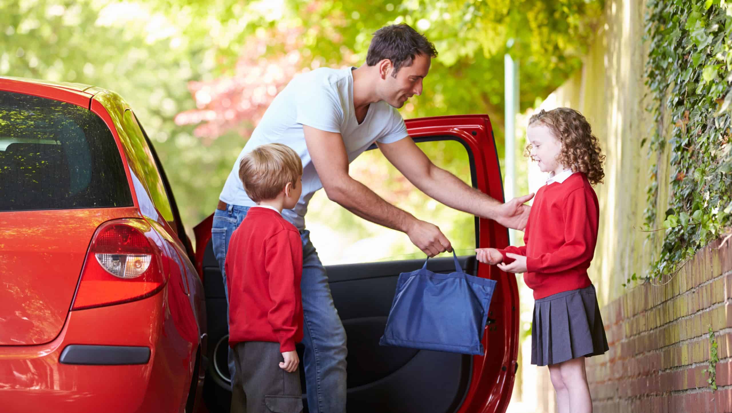 Father Driving To School With Children