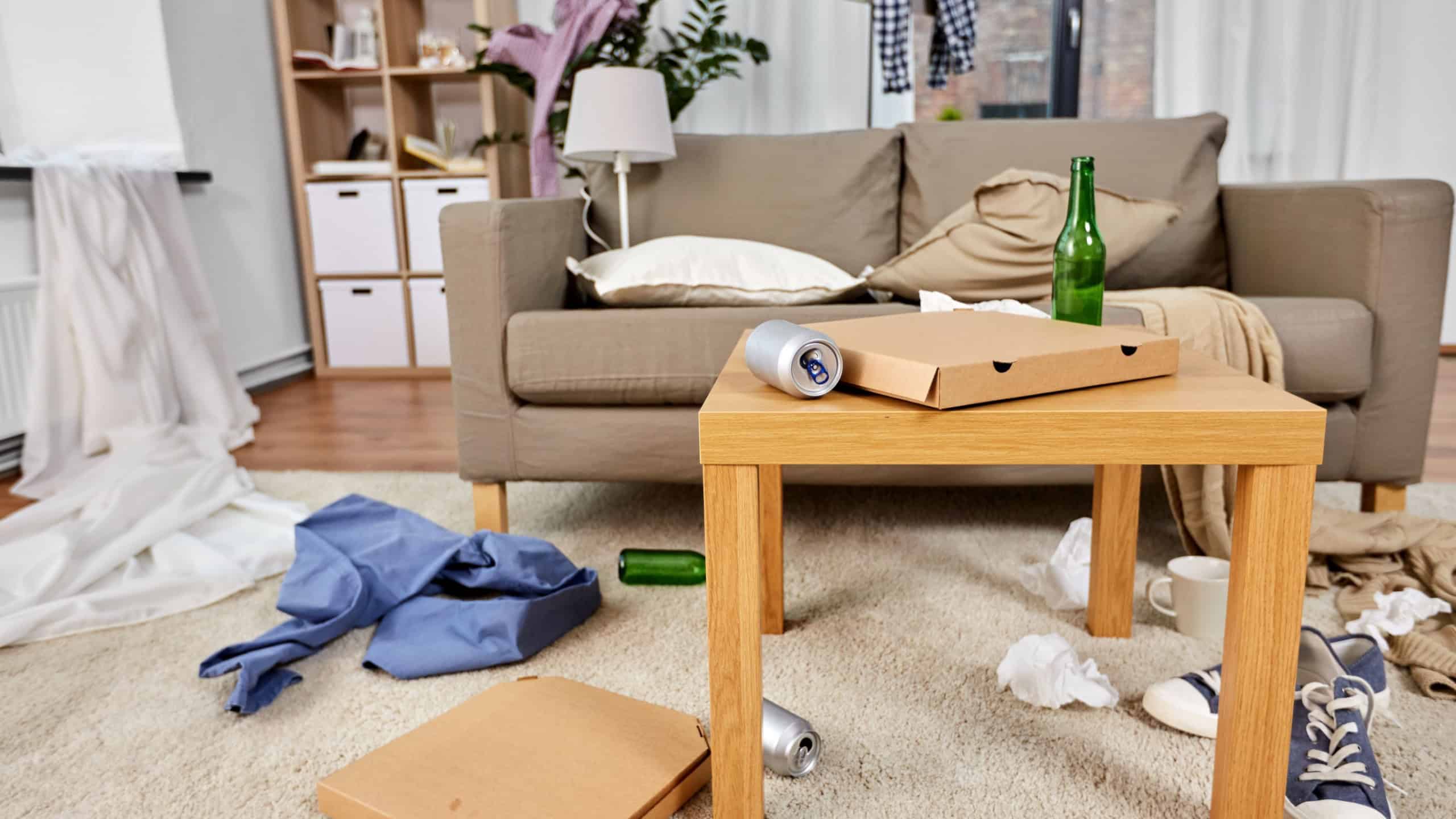 Mess, disorder and interior concept - view of messy home living room with scattered stuff