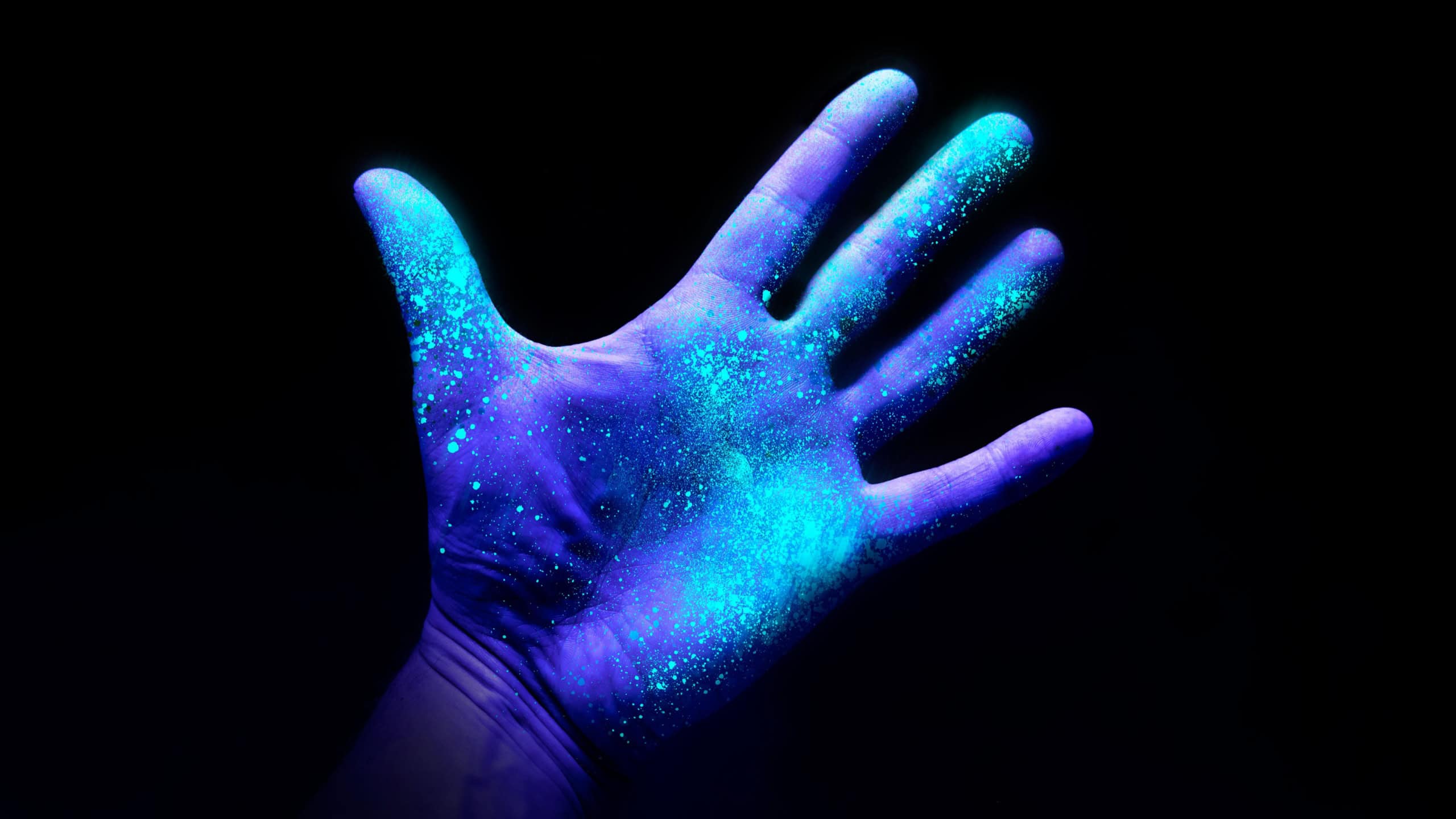 UV Ultraviolet light on a hand illustrating the effect of bacteria and viruses on a surface that has not been washed showing the importance of good hygiene and hand washing.