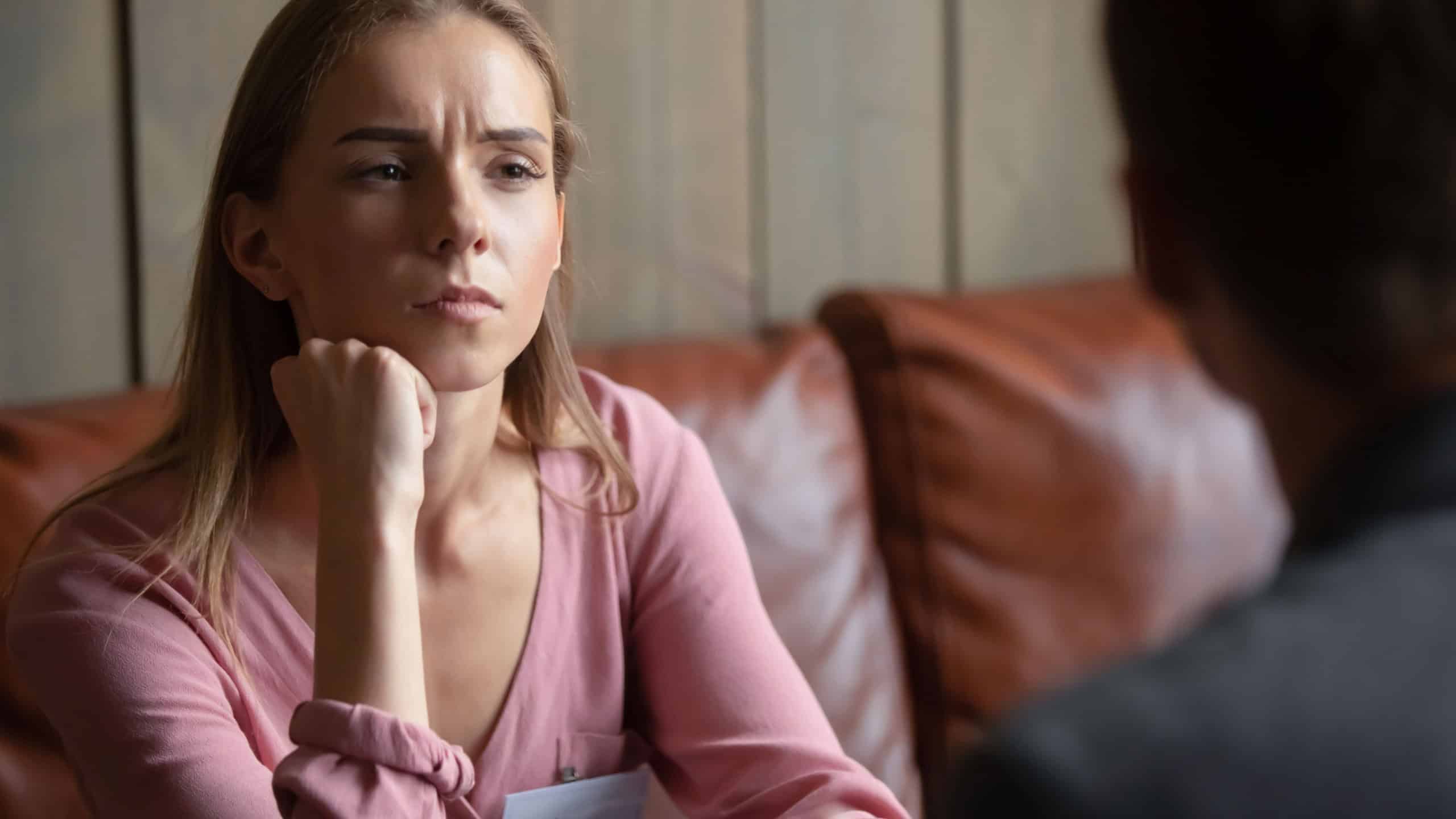 Boring date. Young female sitting at table in coffeehouse having appointment meeting speed dating with male boyfriend feeling dull dissatisfied losing her time, listening to partner without interest