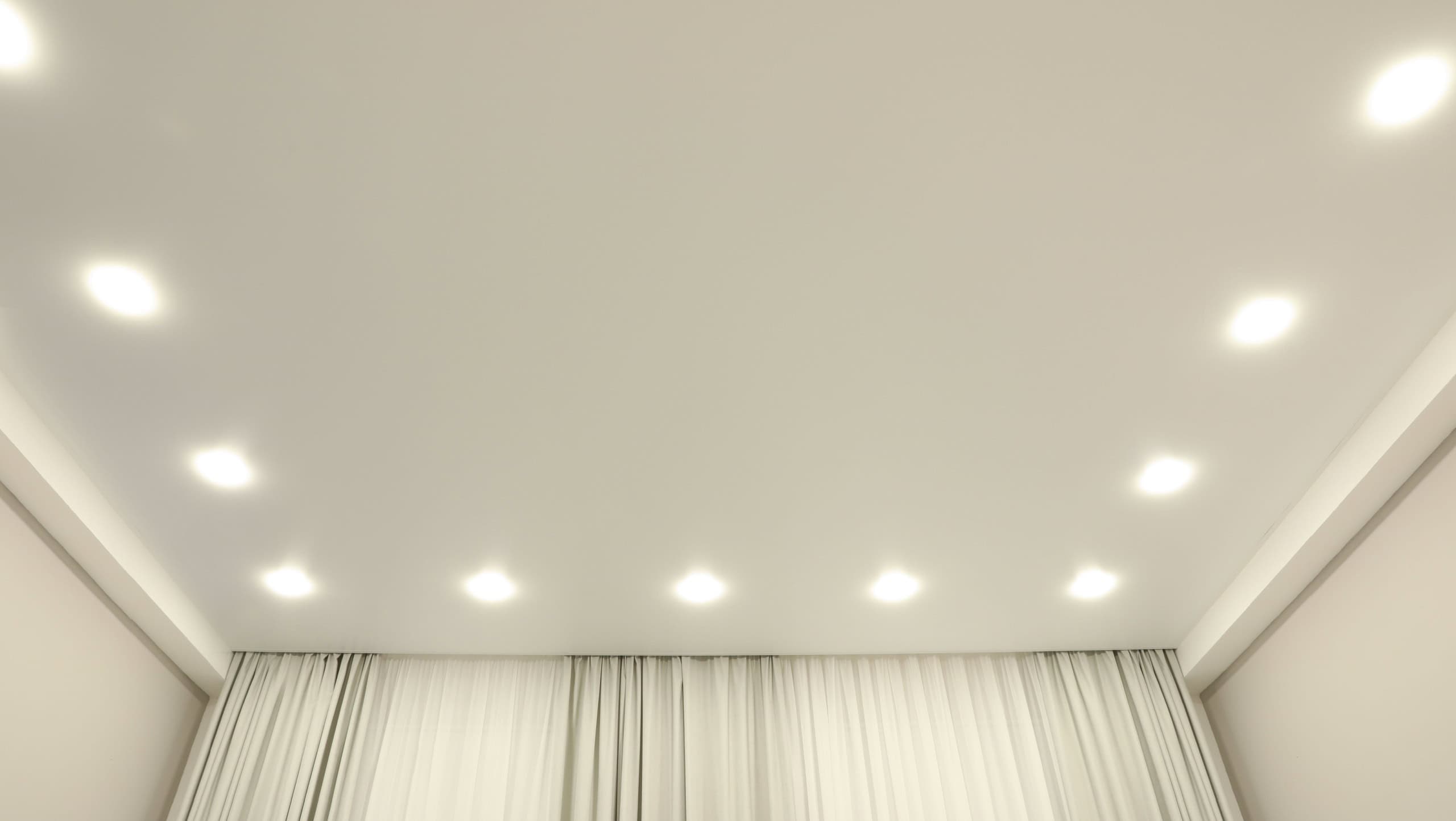 White stretch ceiling with spot lights in room