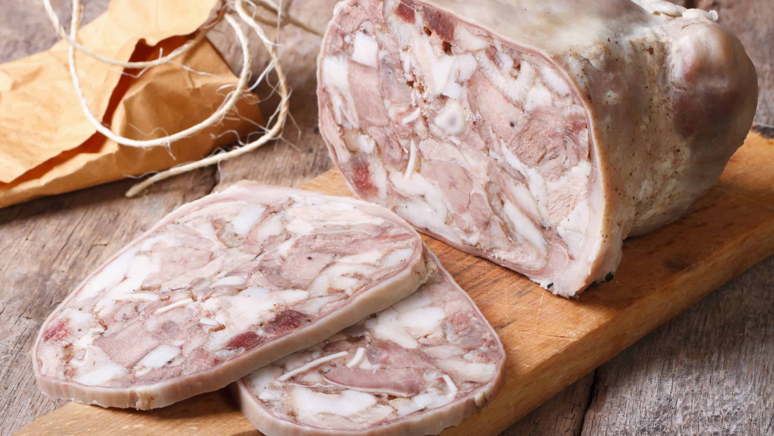 Cut headcheese on chopping board close-up. horizontal