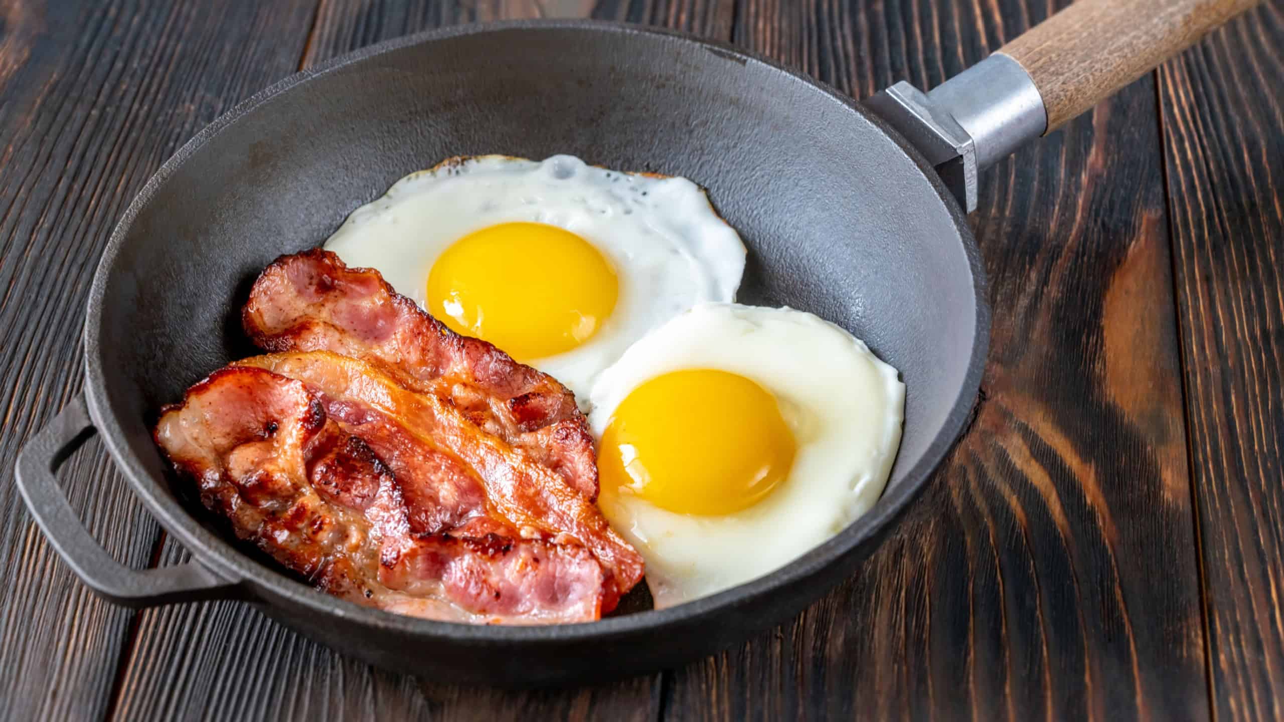 Fried eggs with bacon rashers on the frying pan