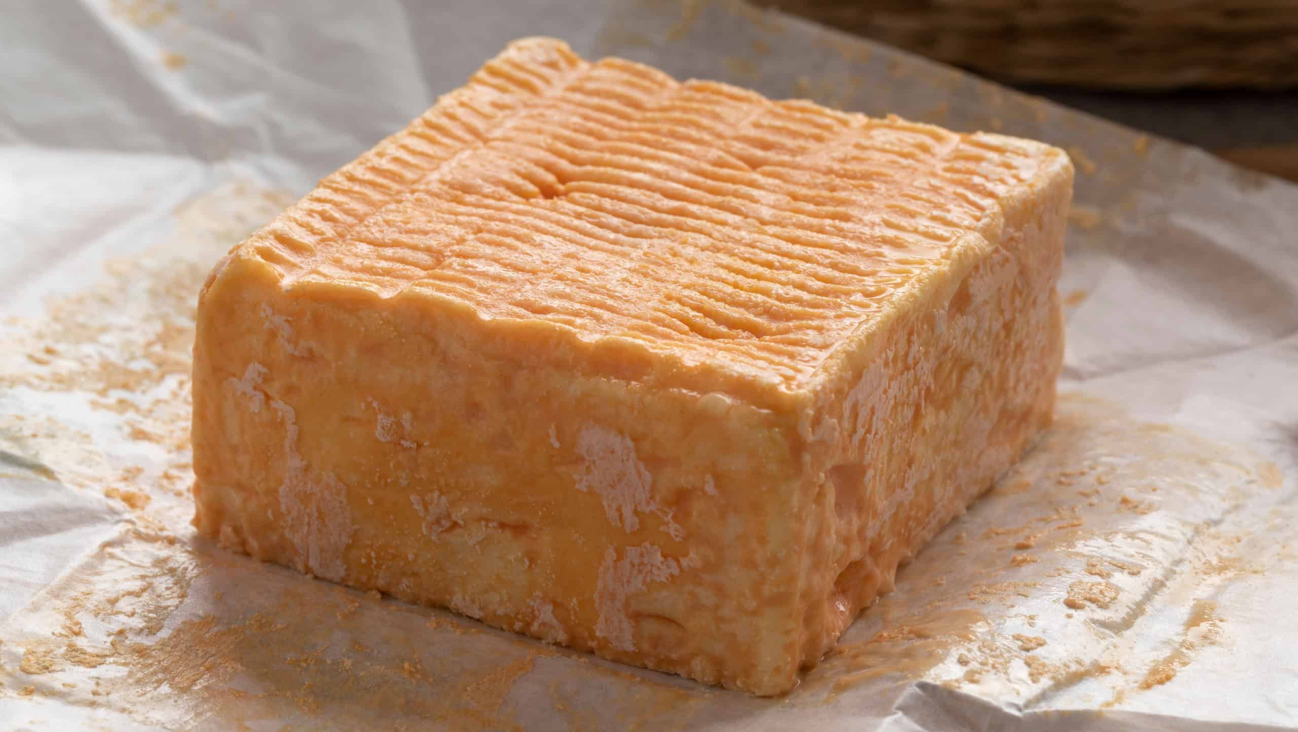 Single whole piece of Limburger or Herve cheese with a strong smell on package paper
