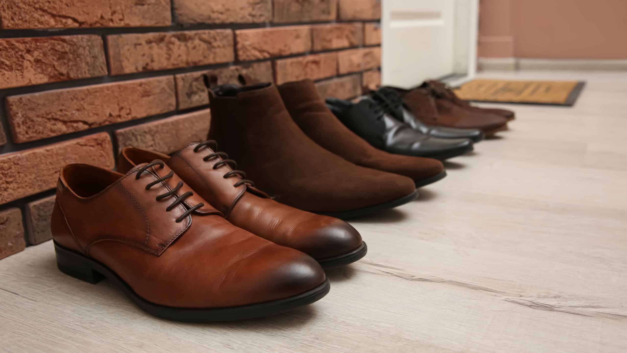 Different shoes near red brick wall in hallway
