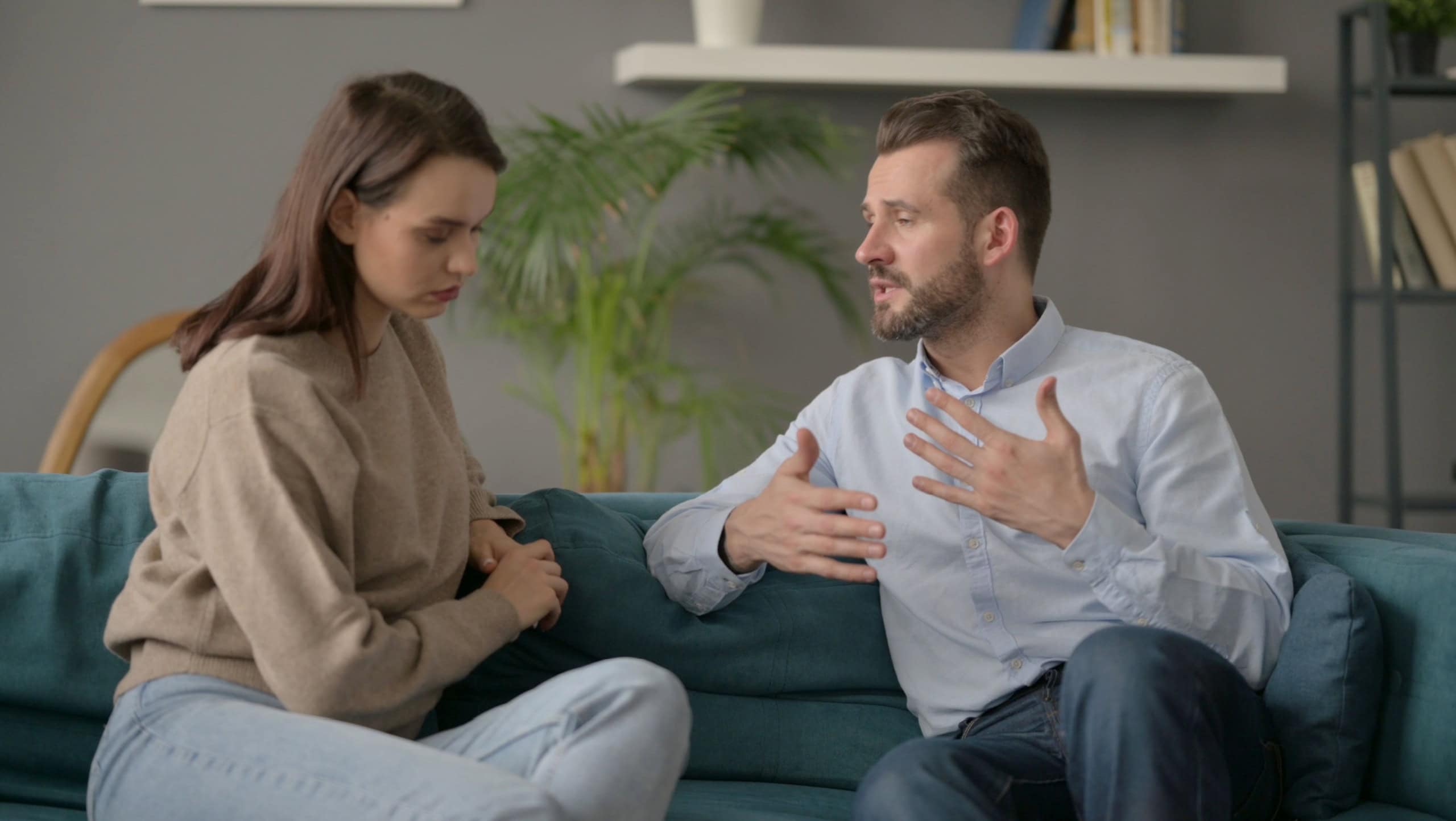 Serious Man Talking to Woman While Sitting on Sofa