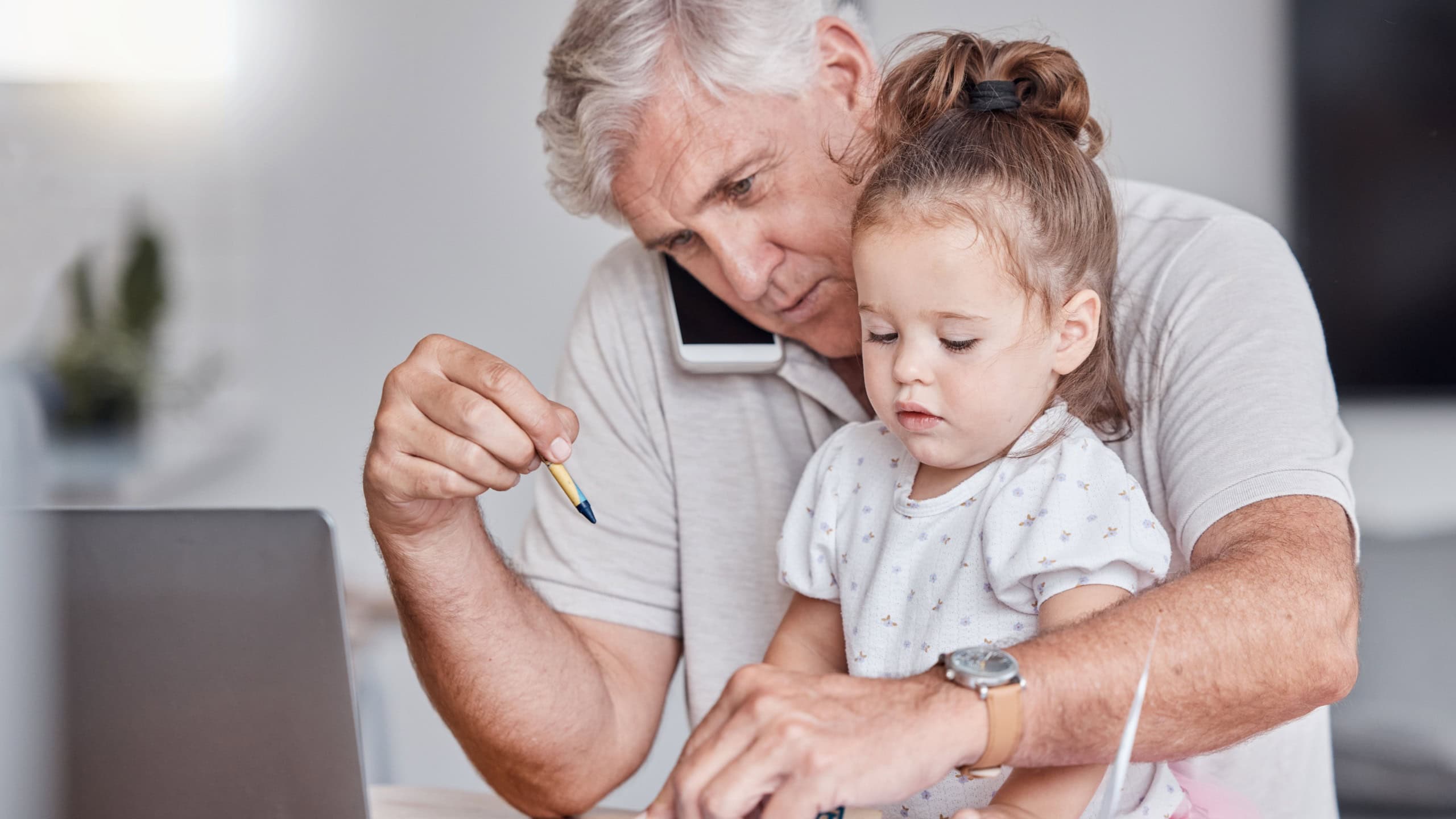 Remote, phone call and grandfather doing business with a child with toys for learning, education and playing in house. Entrepreneur, networking and senior man with mobile, laptop and girl with blocks