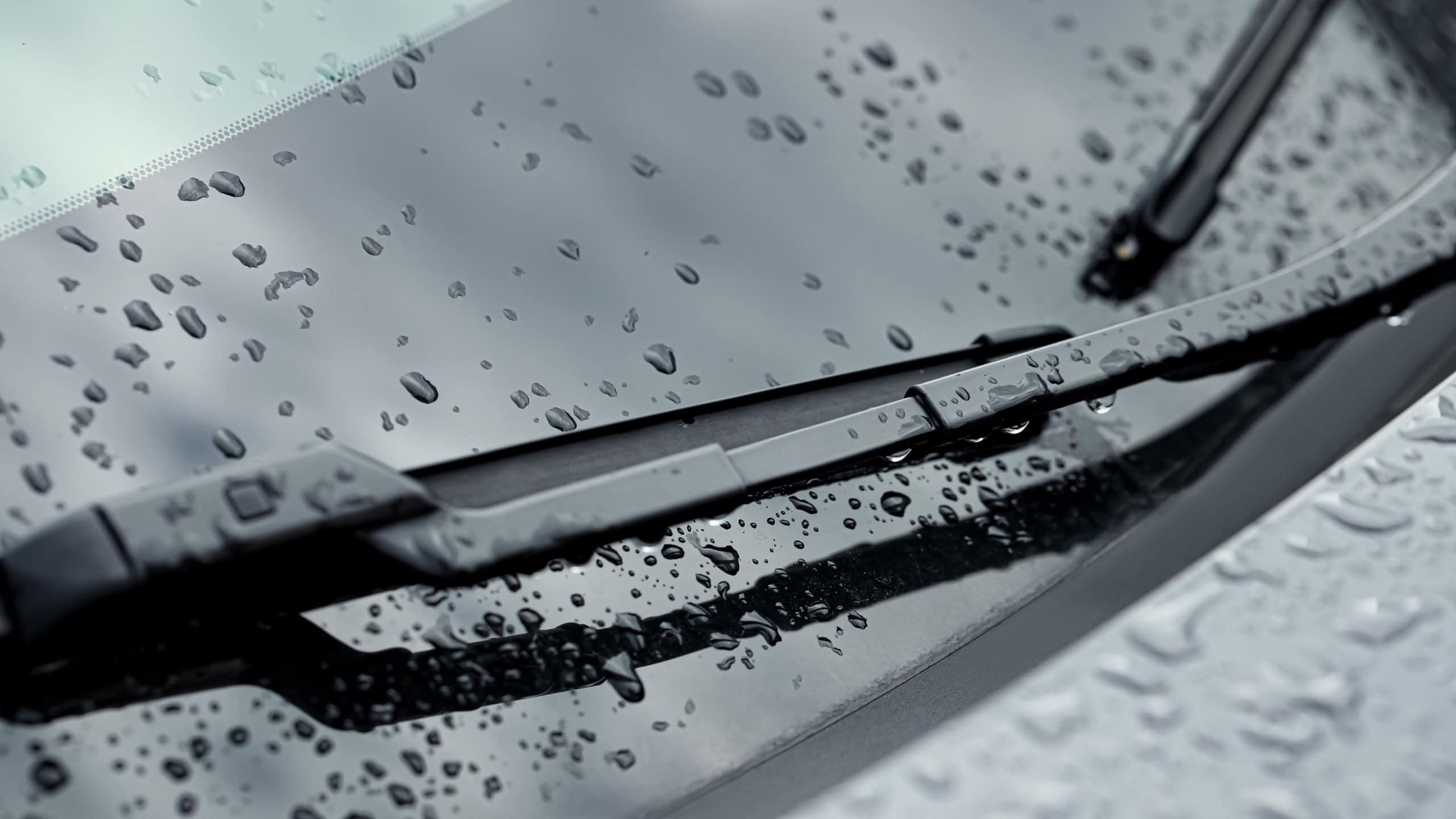 Car wipers and water drops on windshield glass