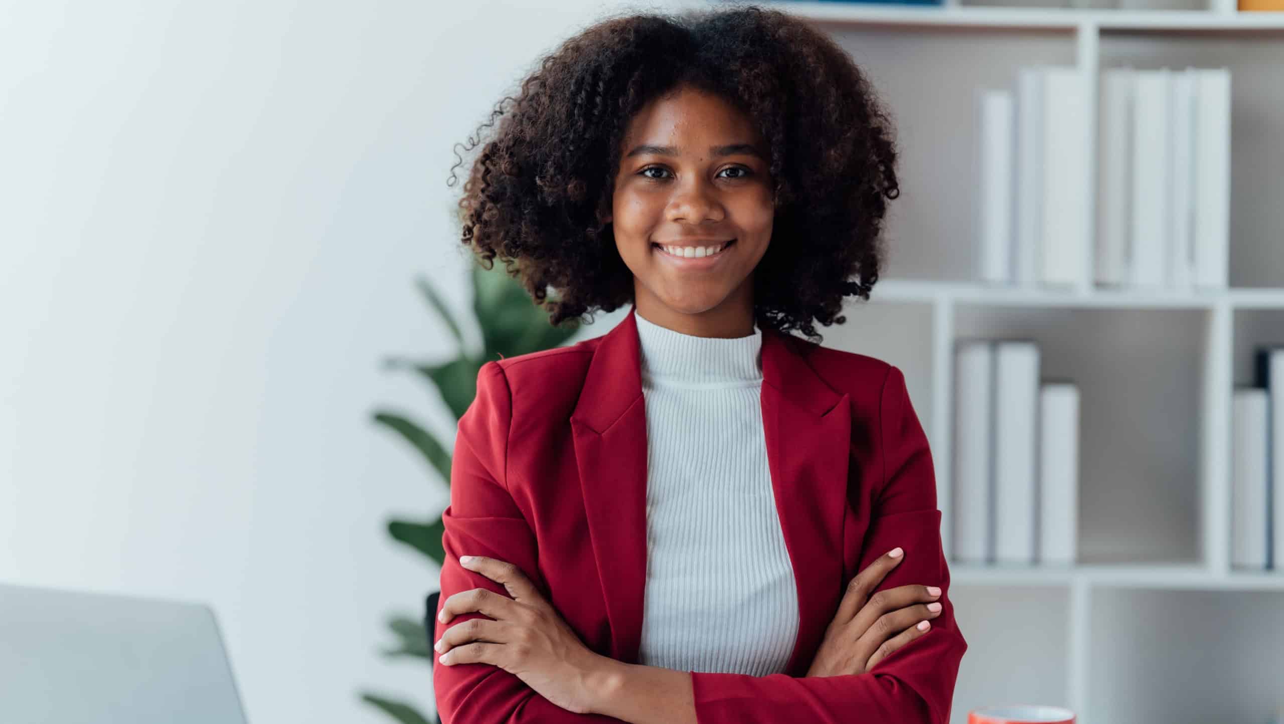 happy young businesswoman African American siting on the chiar cheerful demeanor raise holding coffee cup smiling looking laptop screen.Making opportunities female working successful in the office.