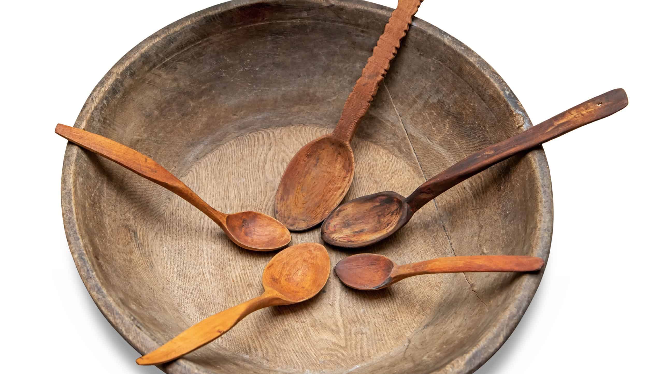Empty wooden cracked bowl with five spoon made from wood isolated on white background with shadow and clipping path. Concept of hunger. Flat lay, top view