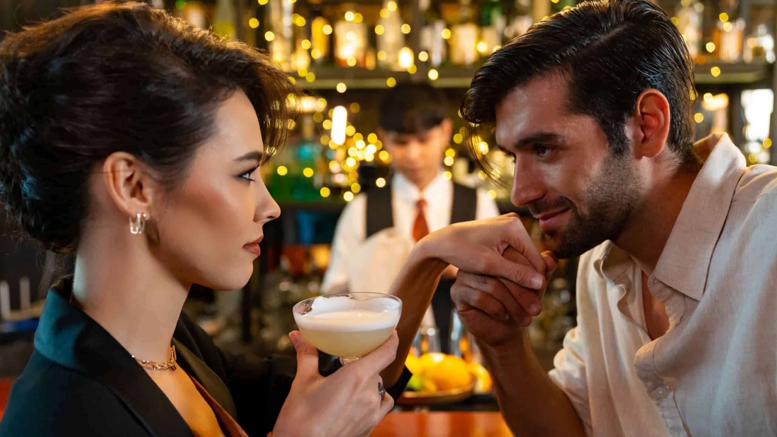 Caucasian man and woman flirting each other while hangout nightlife party at restaurant bar. Attractive female have romantic dating with boyfriend celebrating holiday event together at nightclub