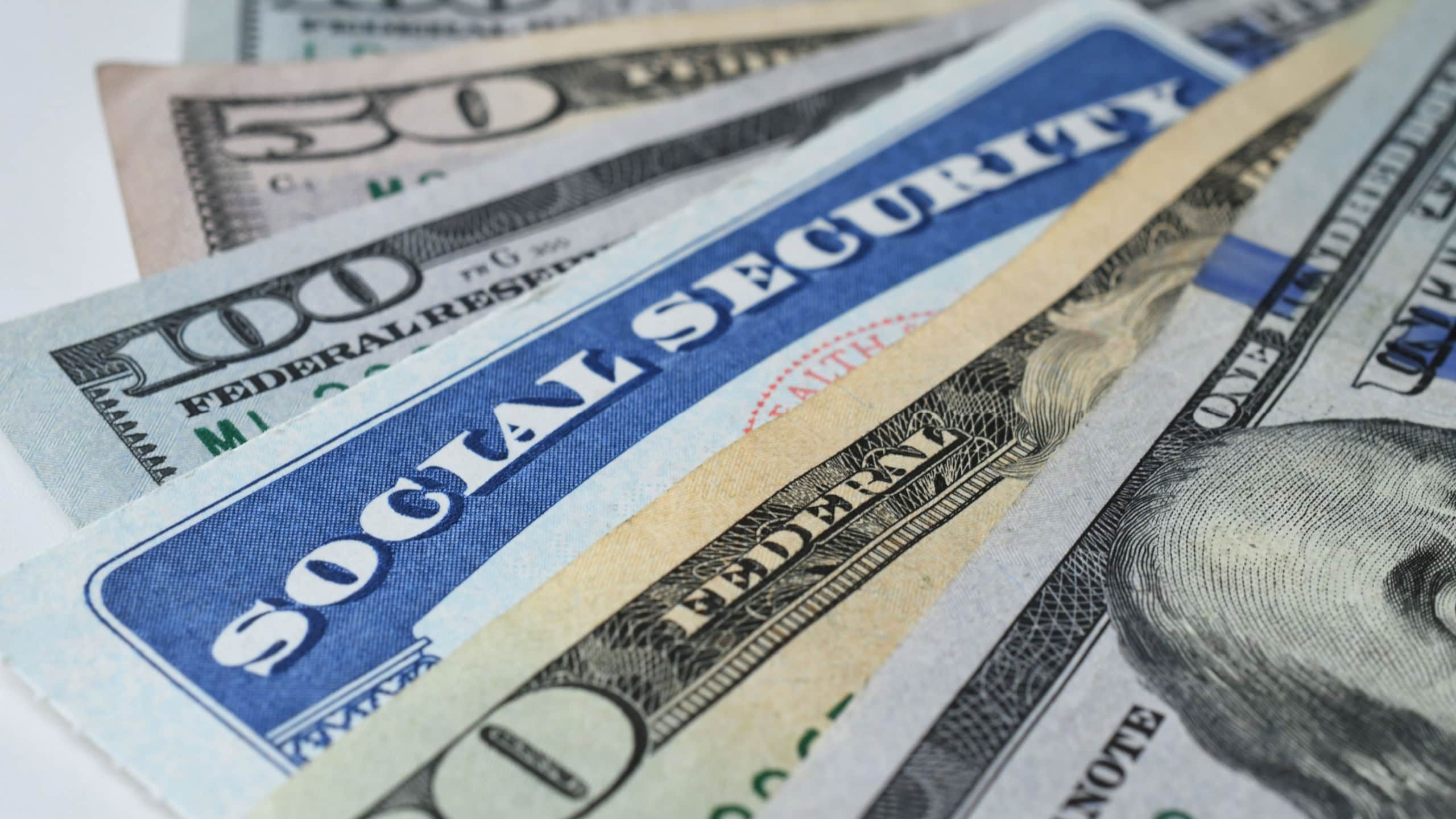 Social Security Card with cash money dollar bills - living on a fixed income, benefits SSN