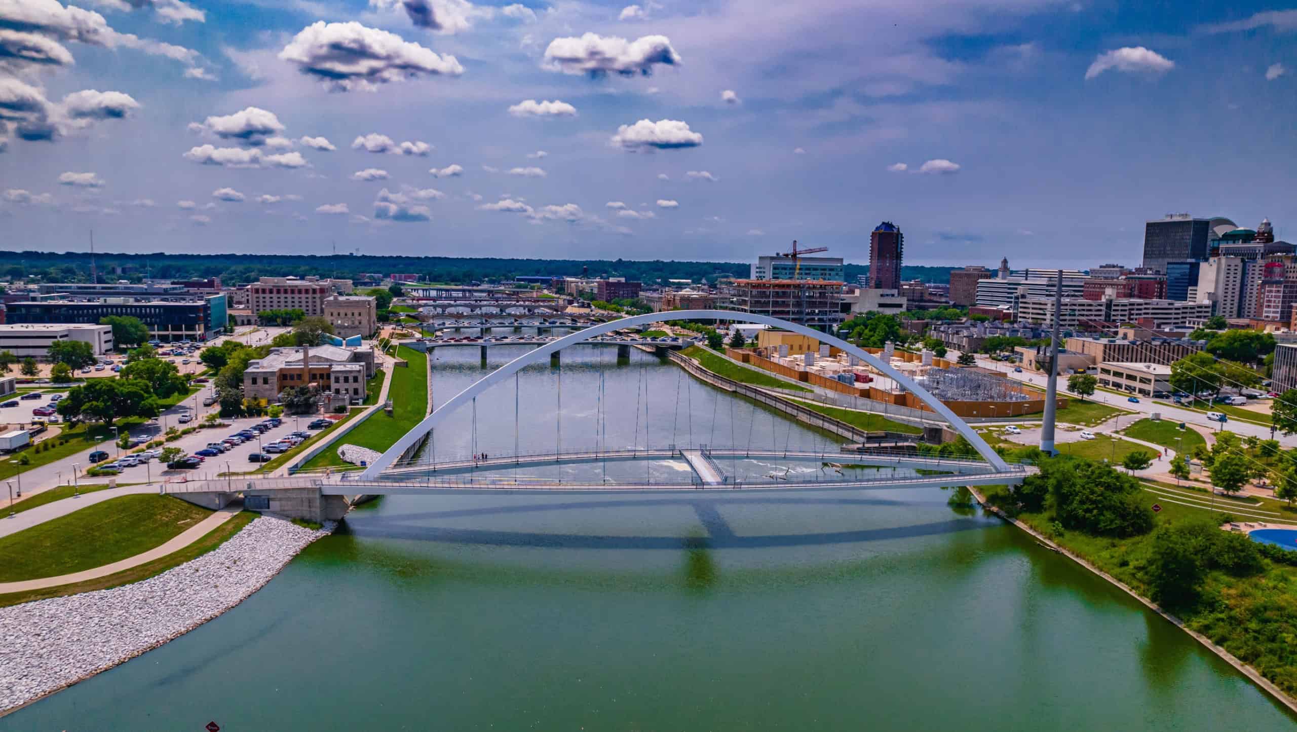 An aerial shot of the Iowa Women of Achievement Bridge across the Des Moines River in Downtown Des Moines, Iowa