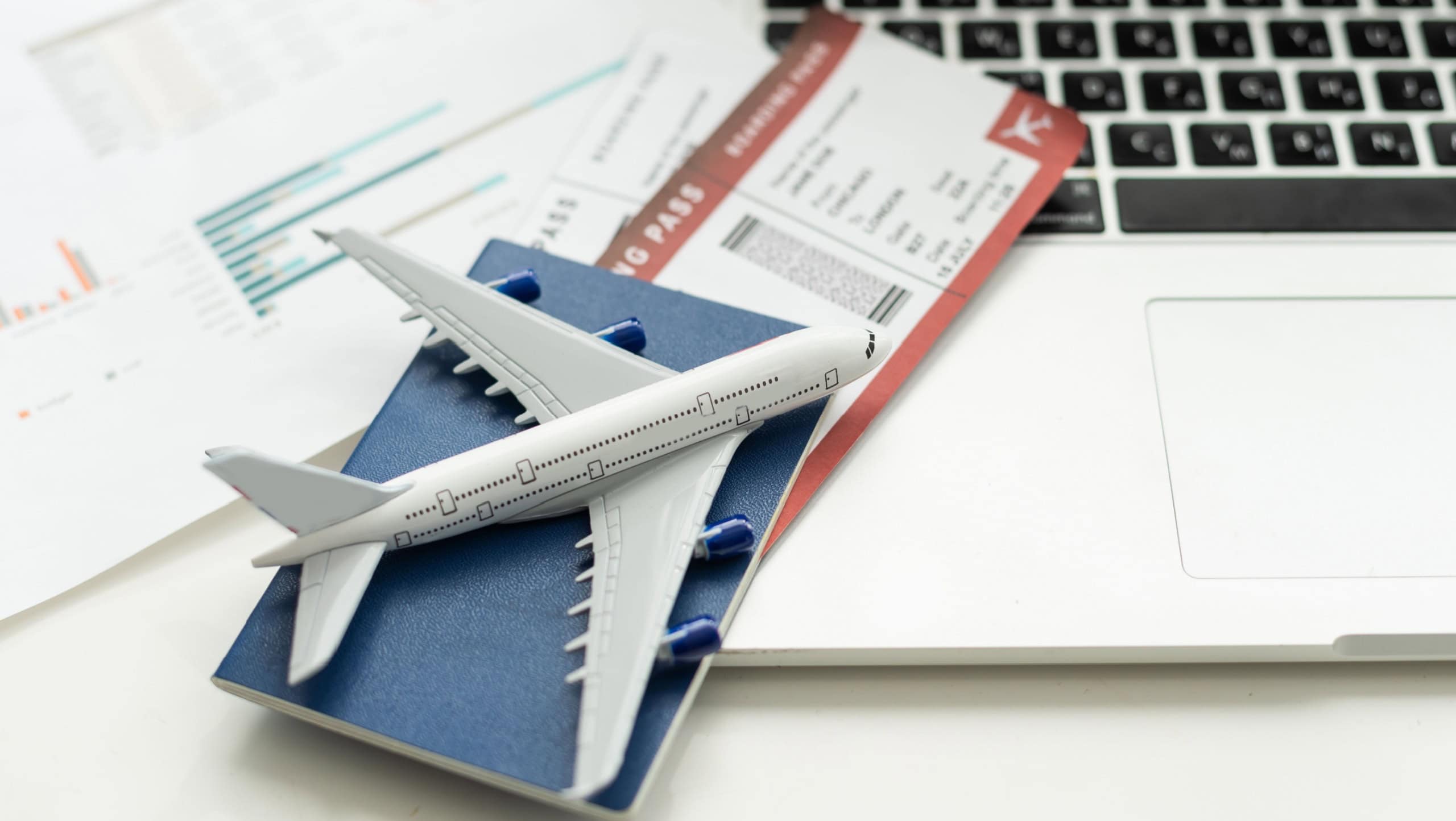 Creative composition. Toy airplane, camera, tickets, money on a white background. Planning a trip, travel, vacation. Air travel. There is free space to insert. Advertising, banner.
