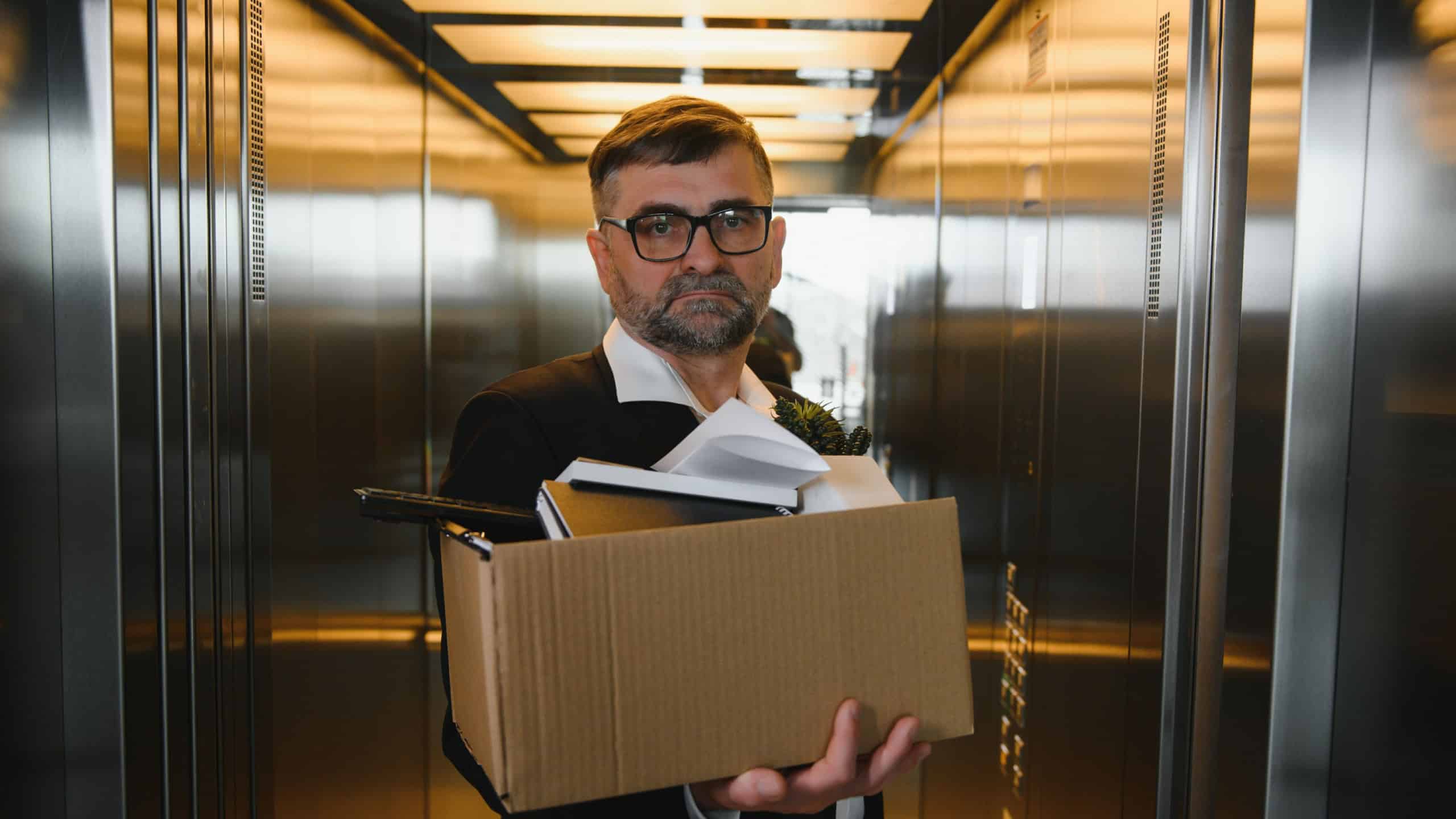 Portrait of sad dismissed senior old business man worker taking his office supplies in the box. Pensioner mature retire from work carry staff back home. Lifestyle business retirement, quit job concept